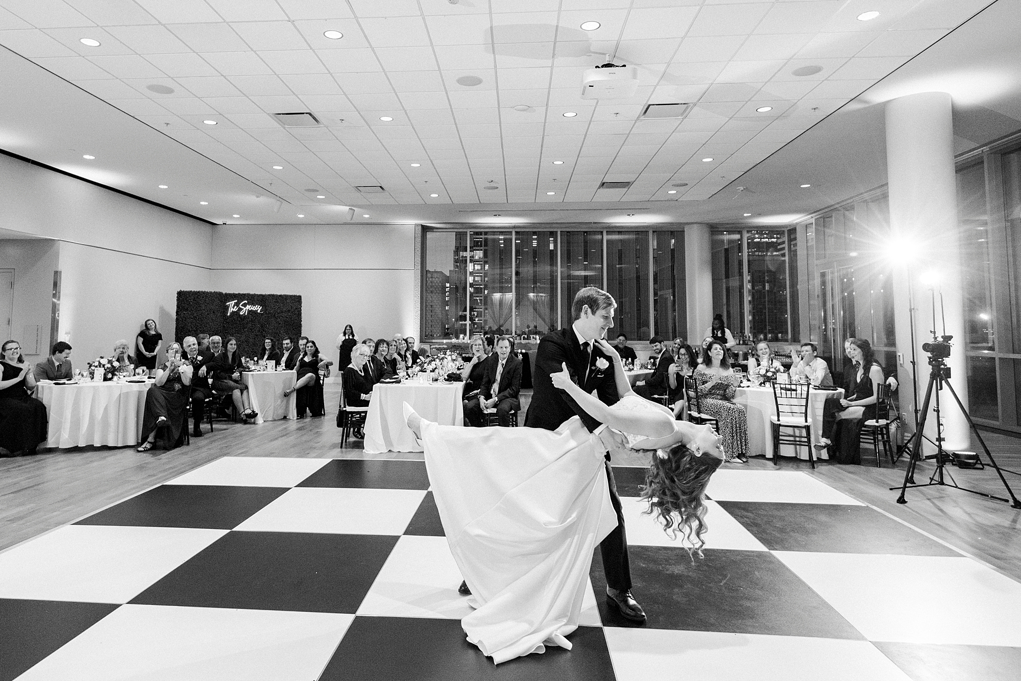 groom dips bride on black and white dance floor at the Mint Museum Uptown
