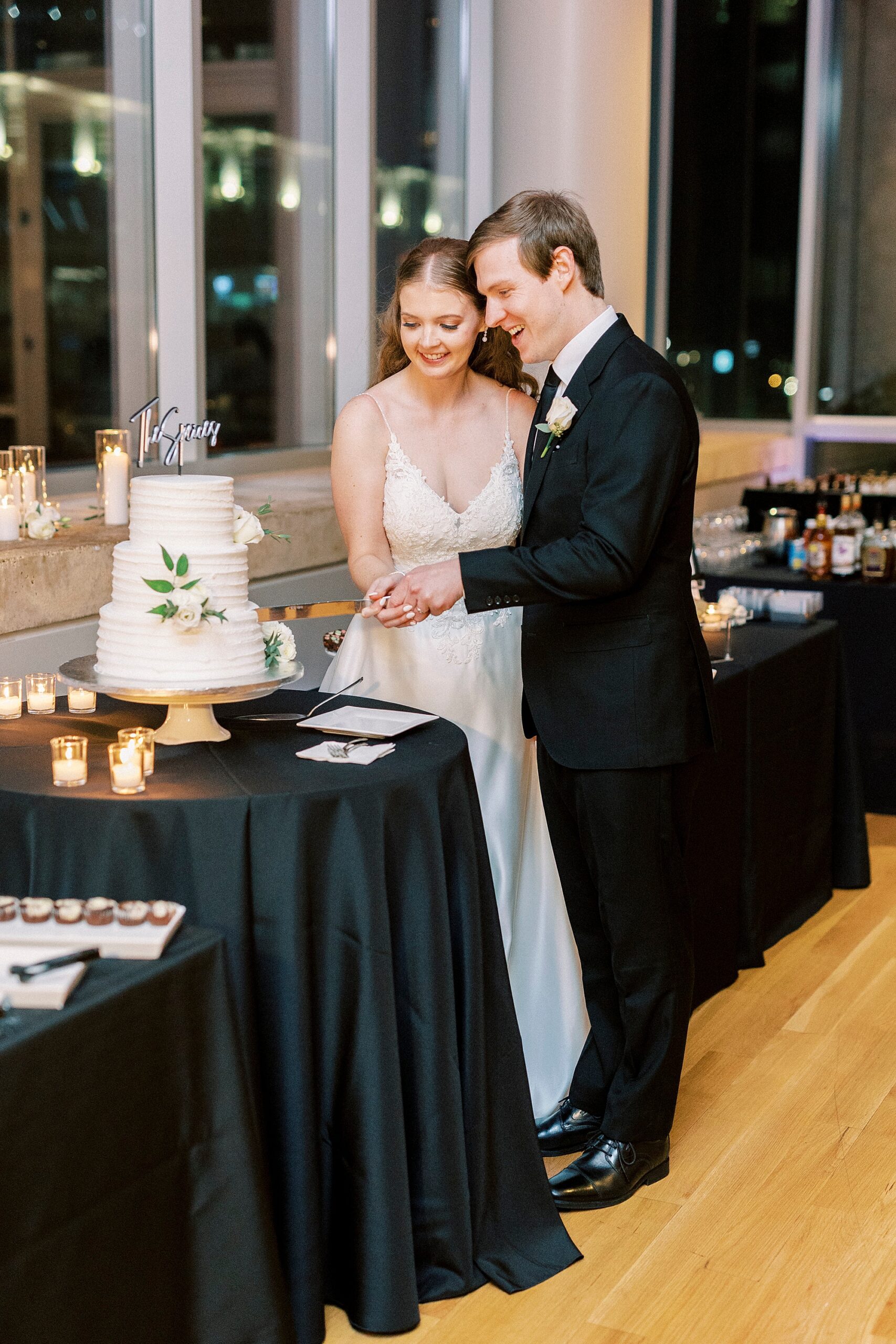 bride and groom cut wedding cake during reception at the Mint Museum Uptown
