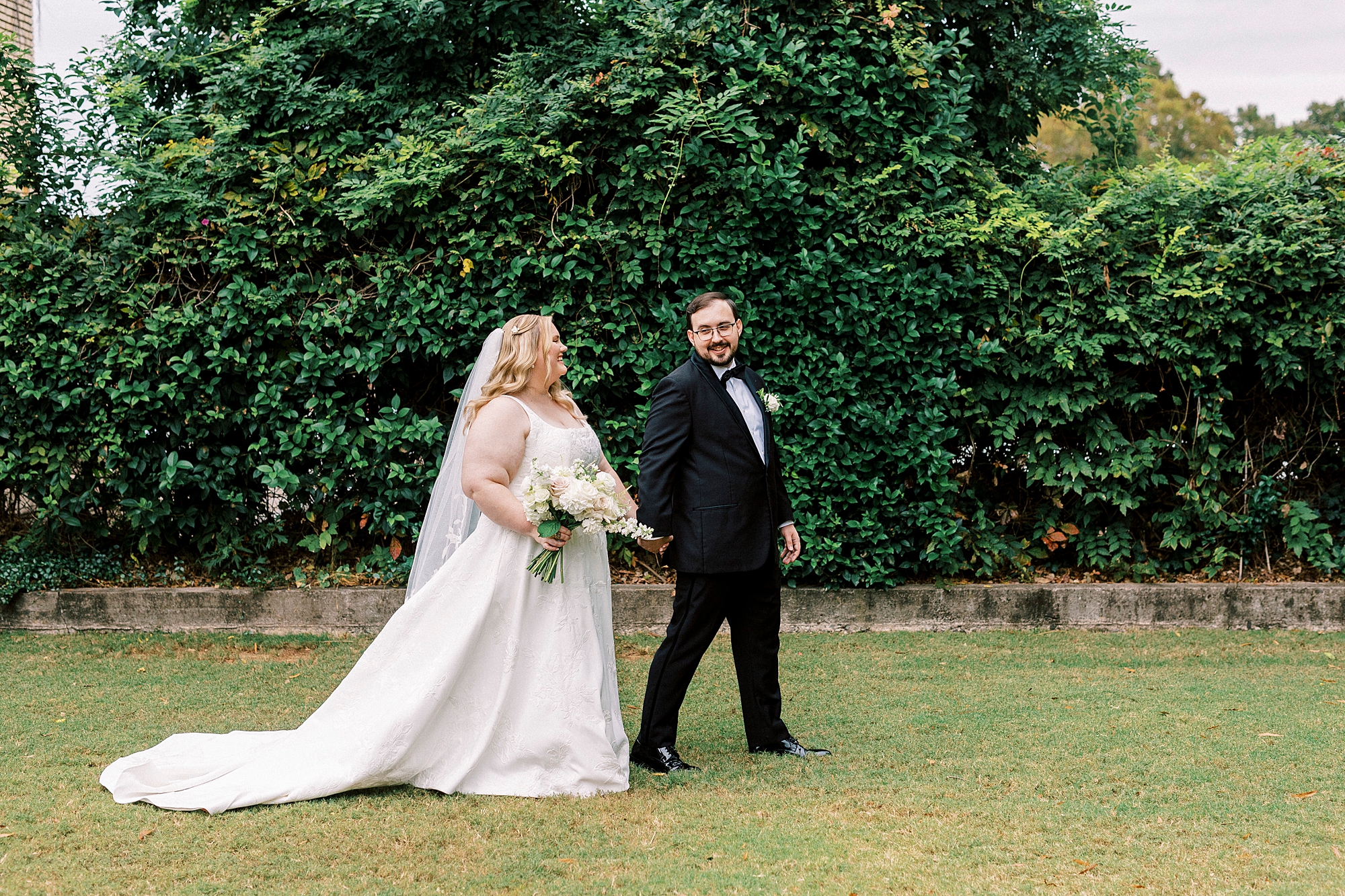 bride and groom hold hands walking across lawn at Separk Mansion