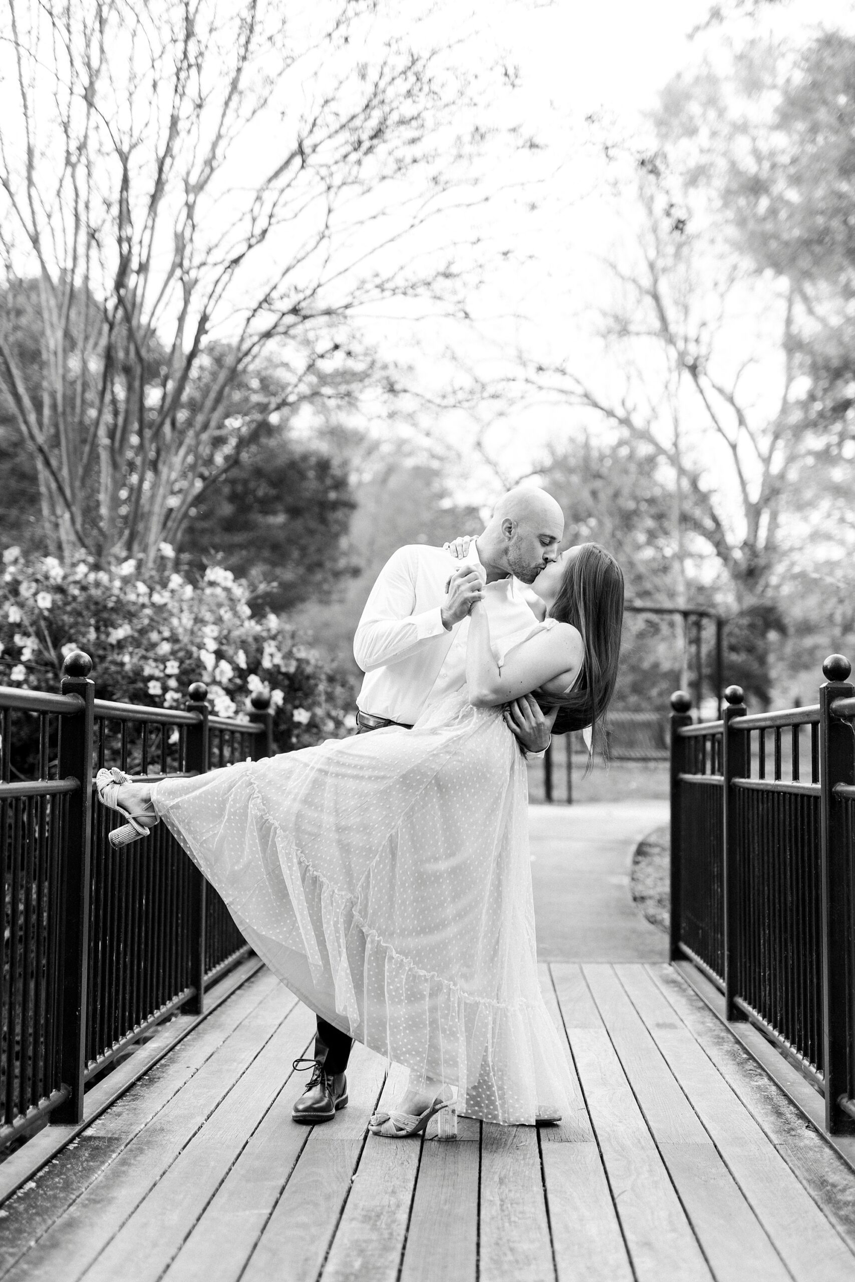 man dips woman on bridge inside Glencairn Garden