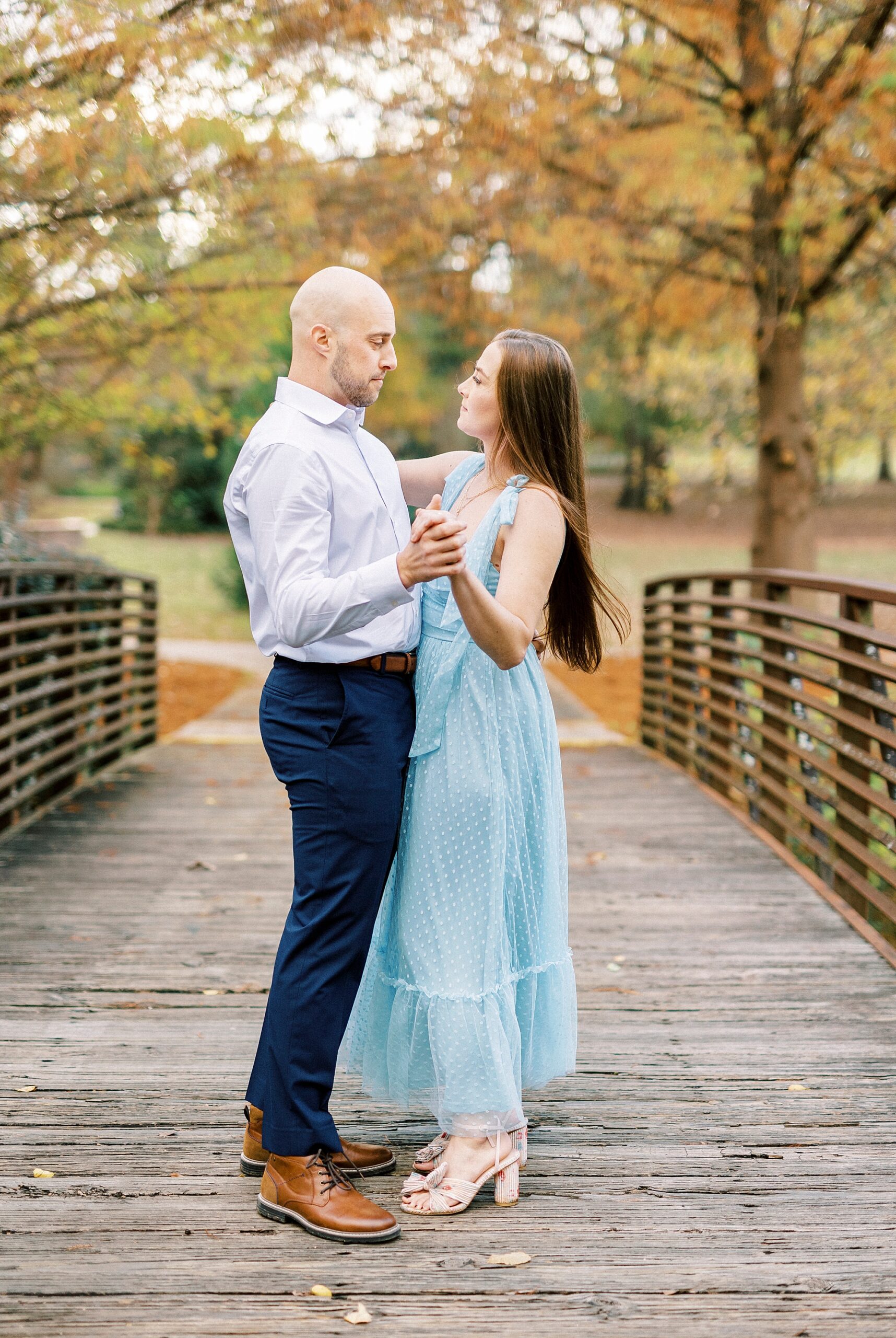 man and woman dance on wooden bridge in Rock Hill SC park