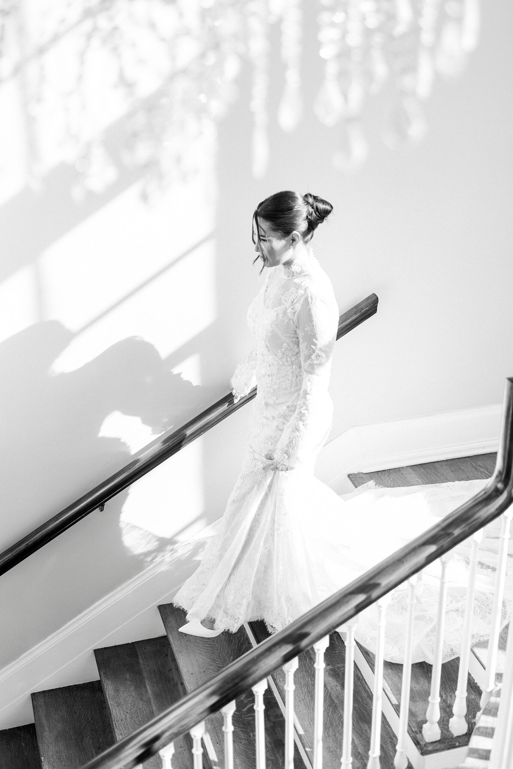 bride walks down staircase inside Separk Mansion in lace wedding gown