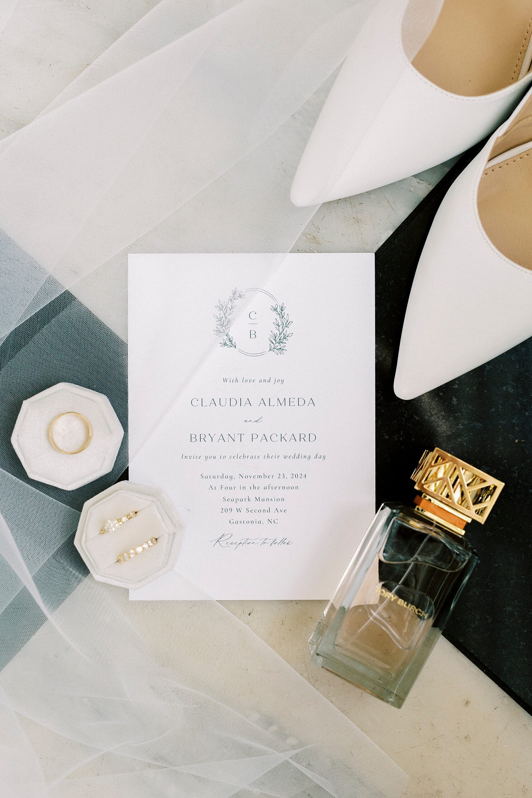 invitation suite on black and white floor with ivory ring box