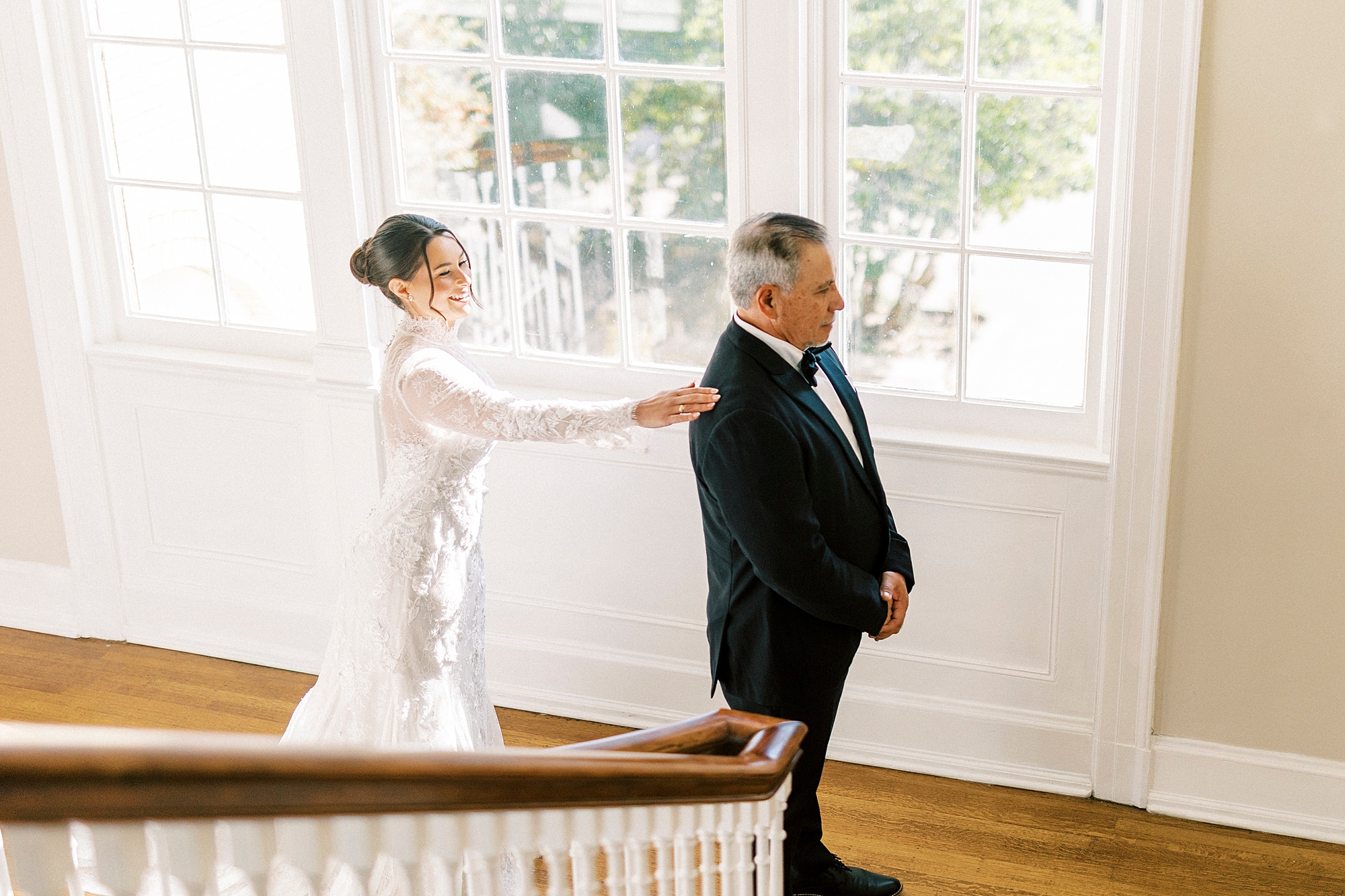 bride reaches to dads shoulder for first look on staircase at Separk Mansion