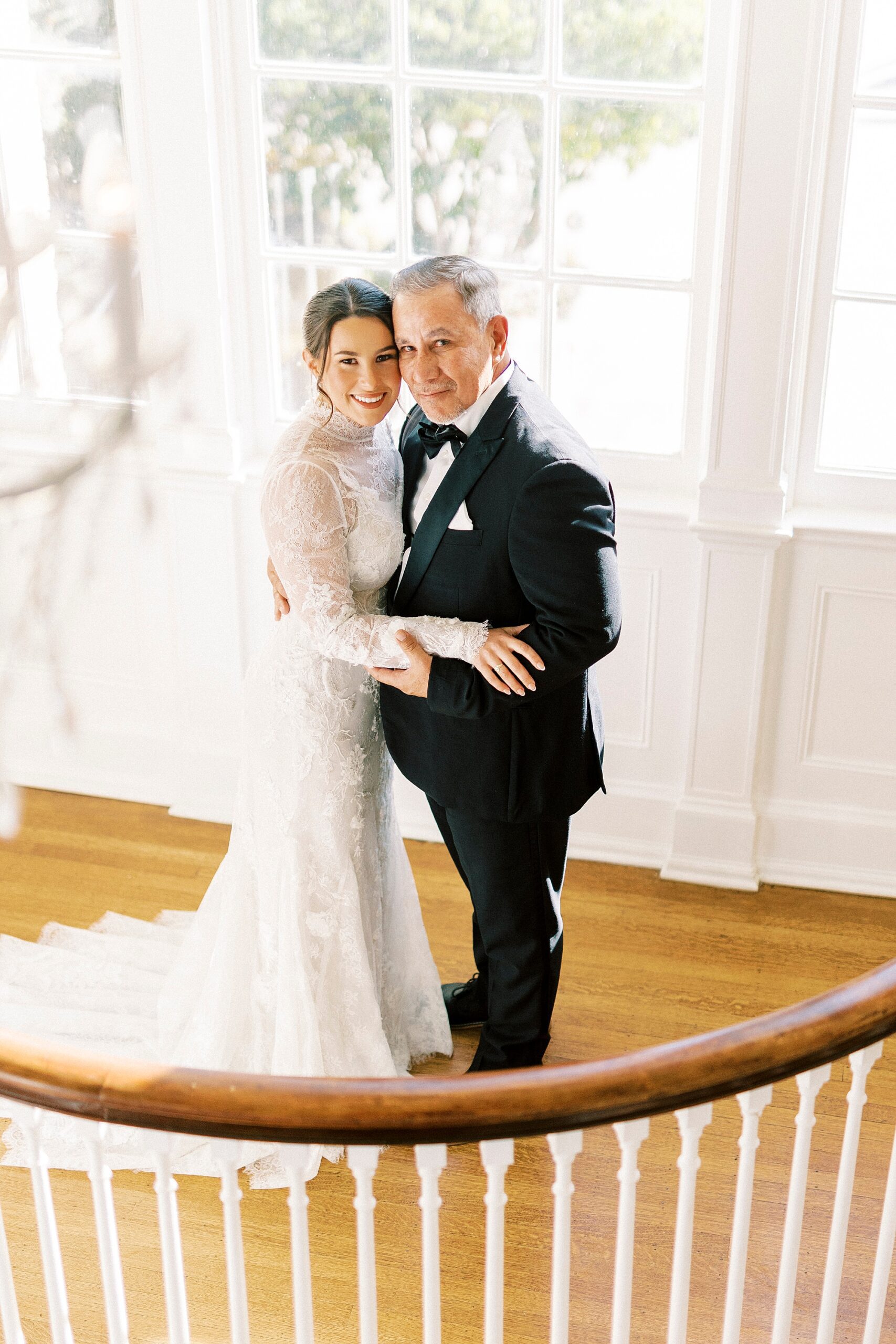 brides hugs father on staircase inside Separk Mansion