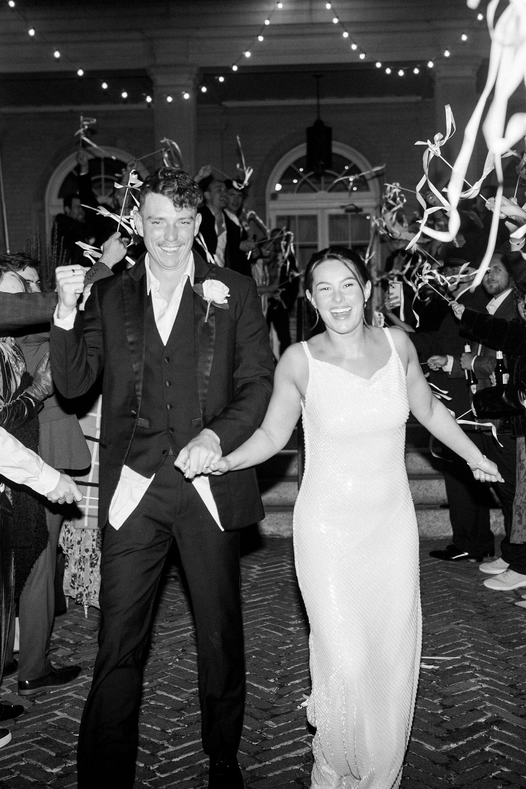 bride and groom hold hands grinning leaving wedding reception at Separk Mansion
