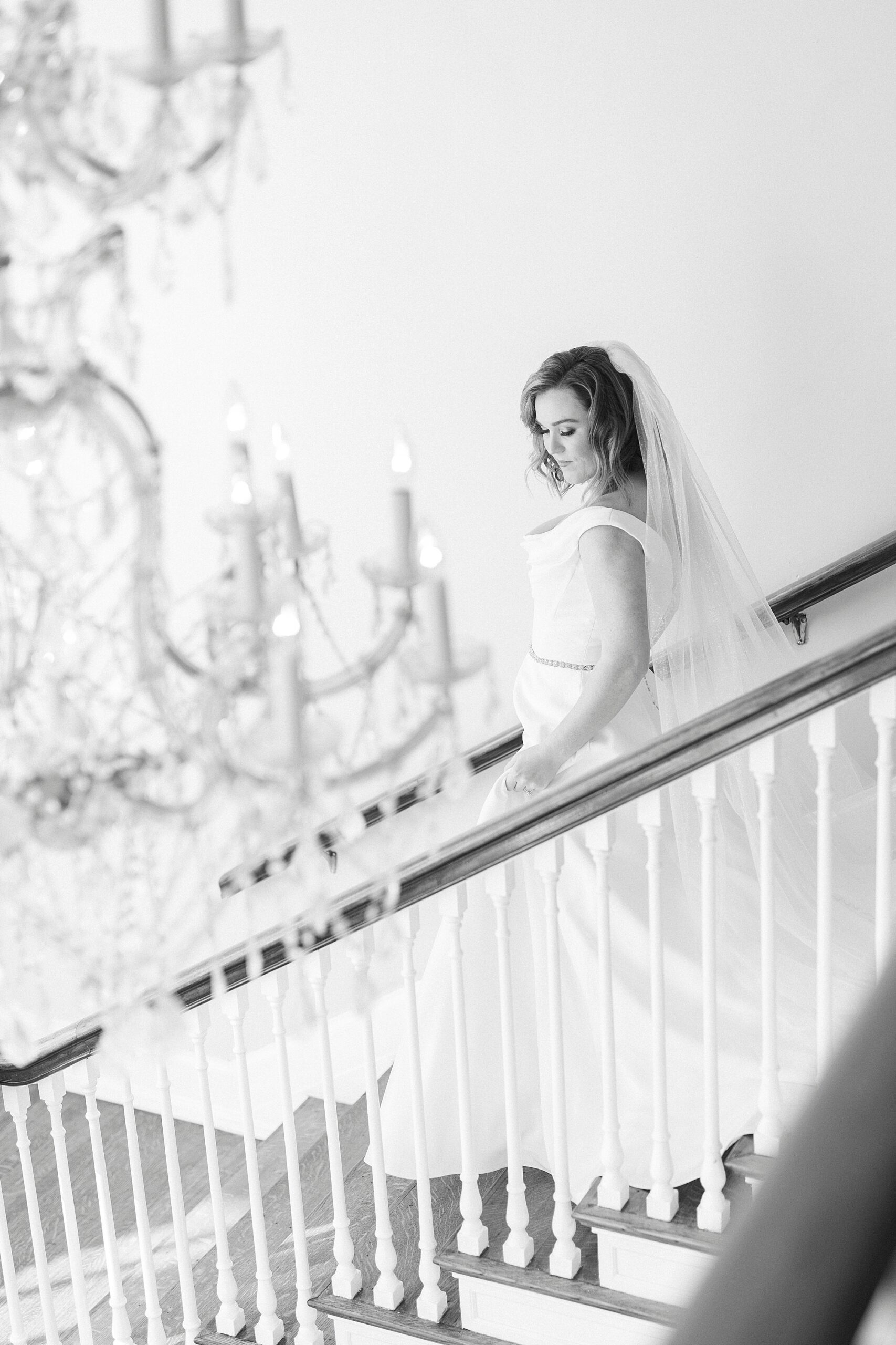 bride walks down staircase inside Separk Mansion in Justin Alexander wedding gown