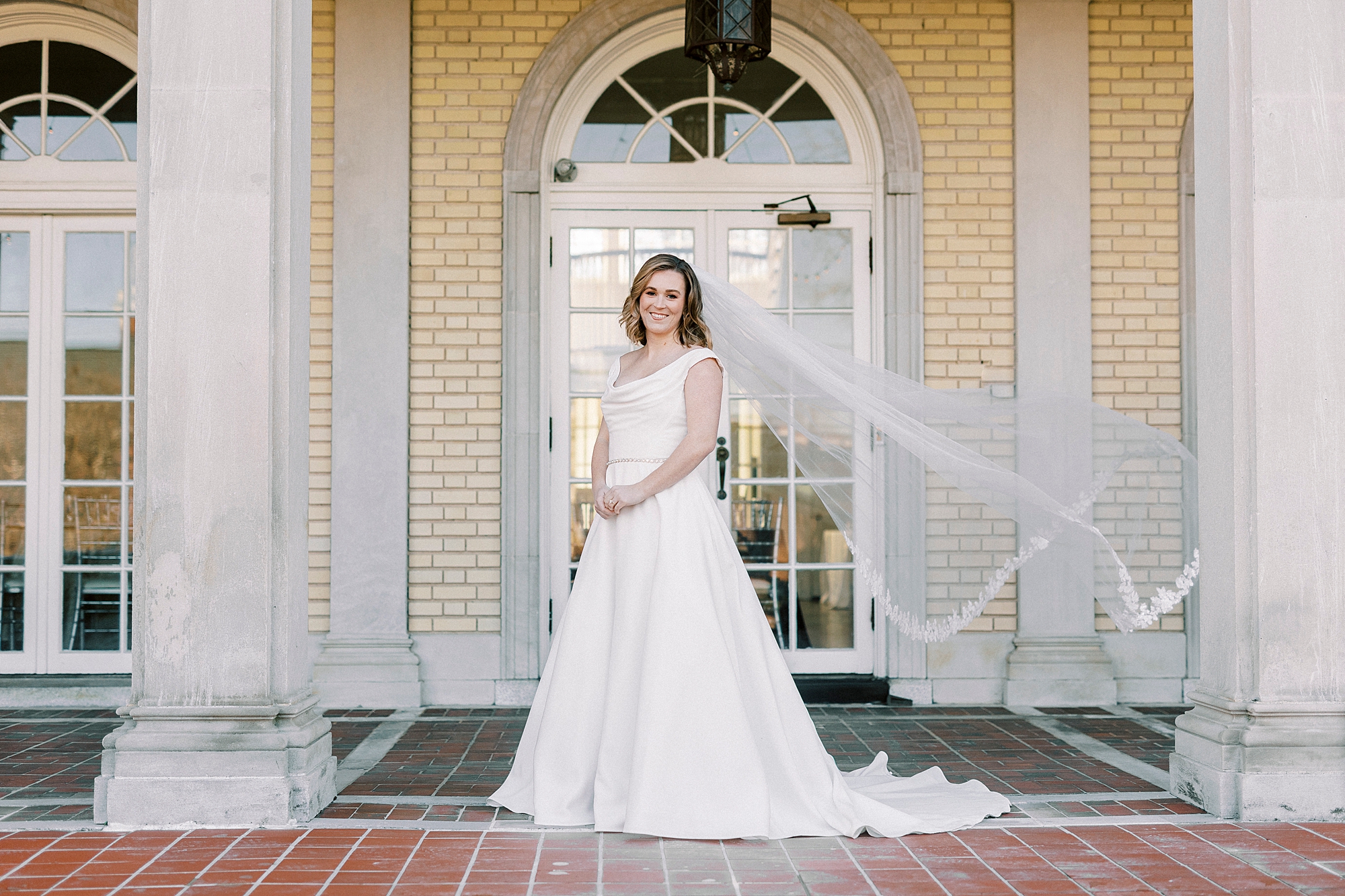 bride stands in front of front doors at Separk Mansion