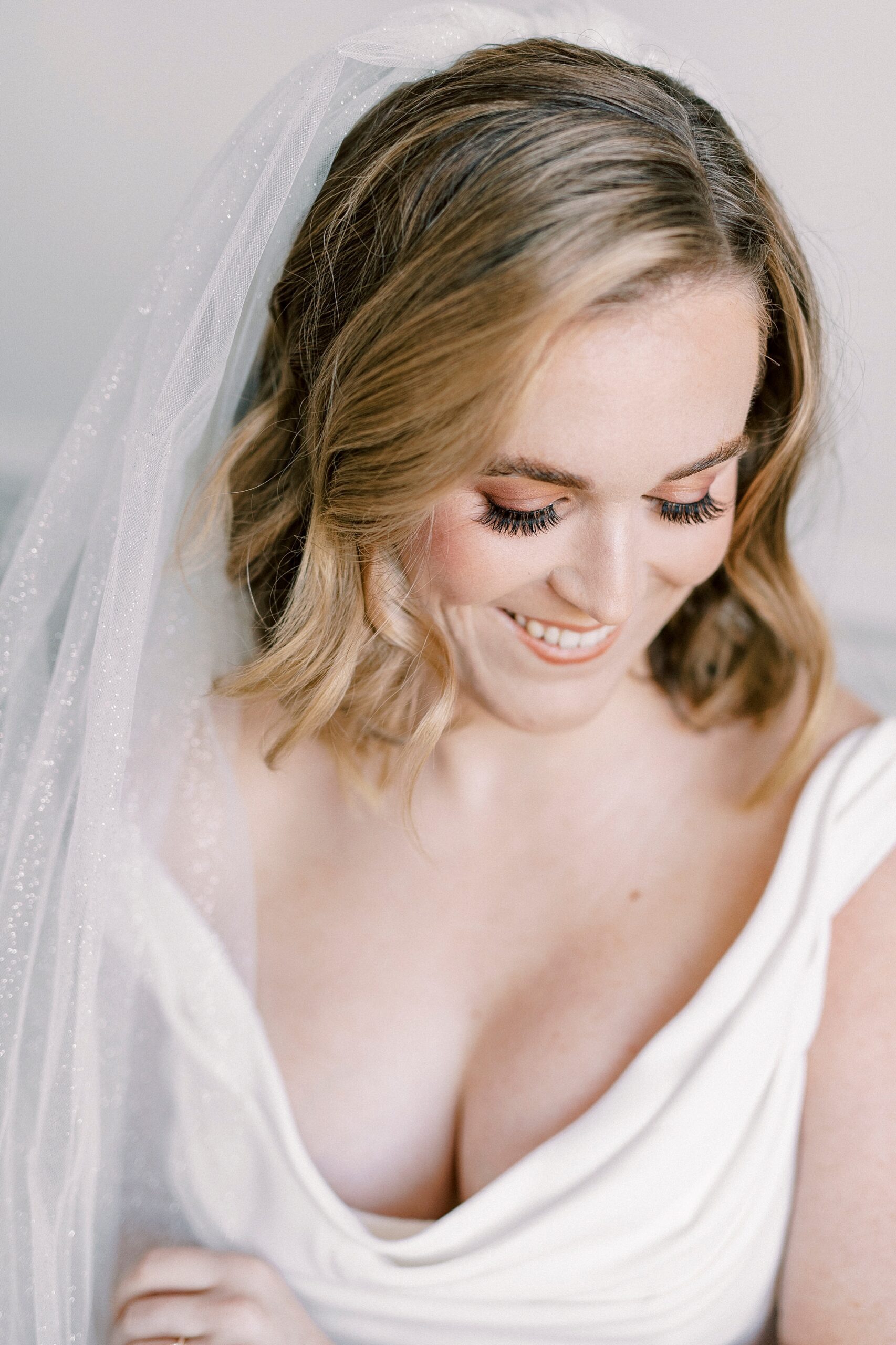 bride looks down smiling during classic bridal portraits at Spark Mansion