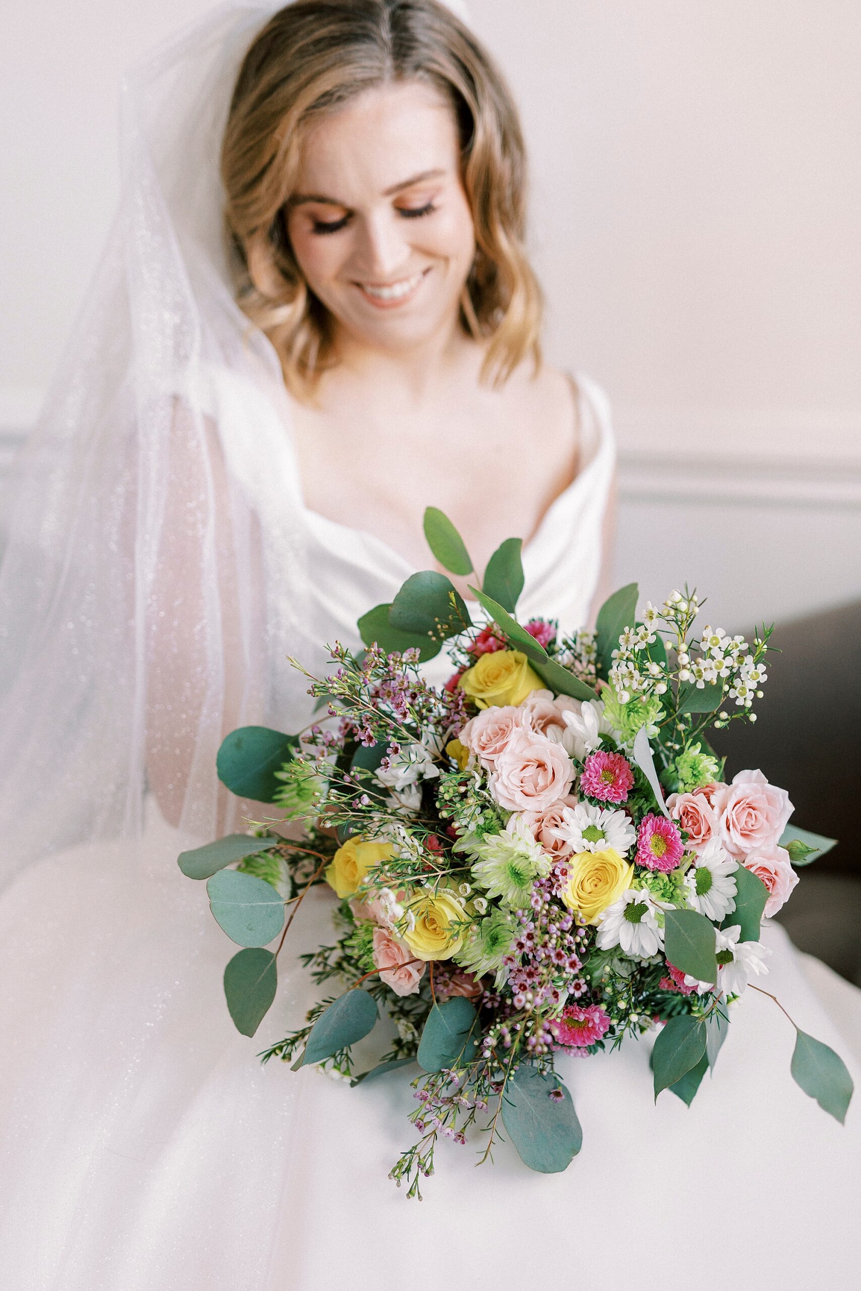 bride holds colorful bouquet of mixed flowers during classic bridal portraits at Spark Mansion