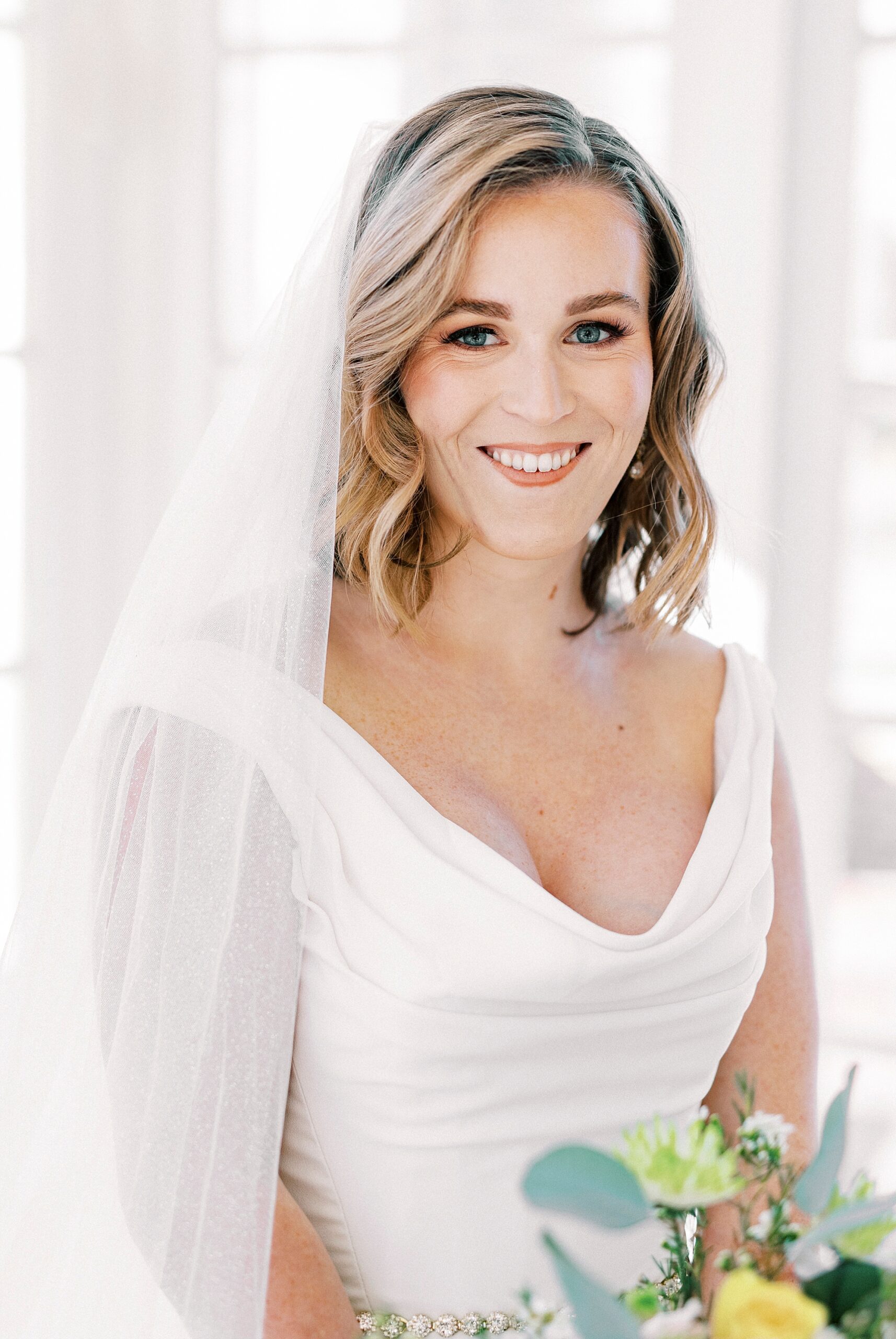 bride smiles holding bouquet of bright flowers at Separk Mansion