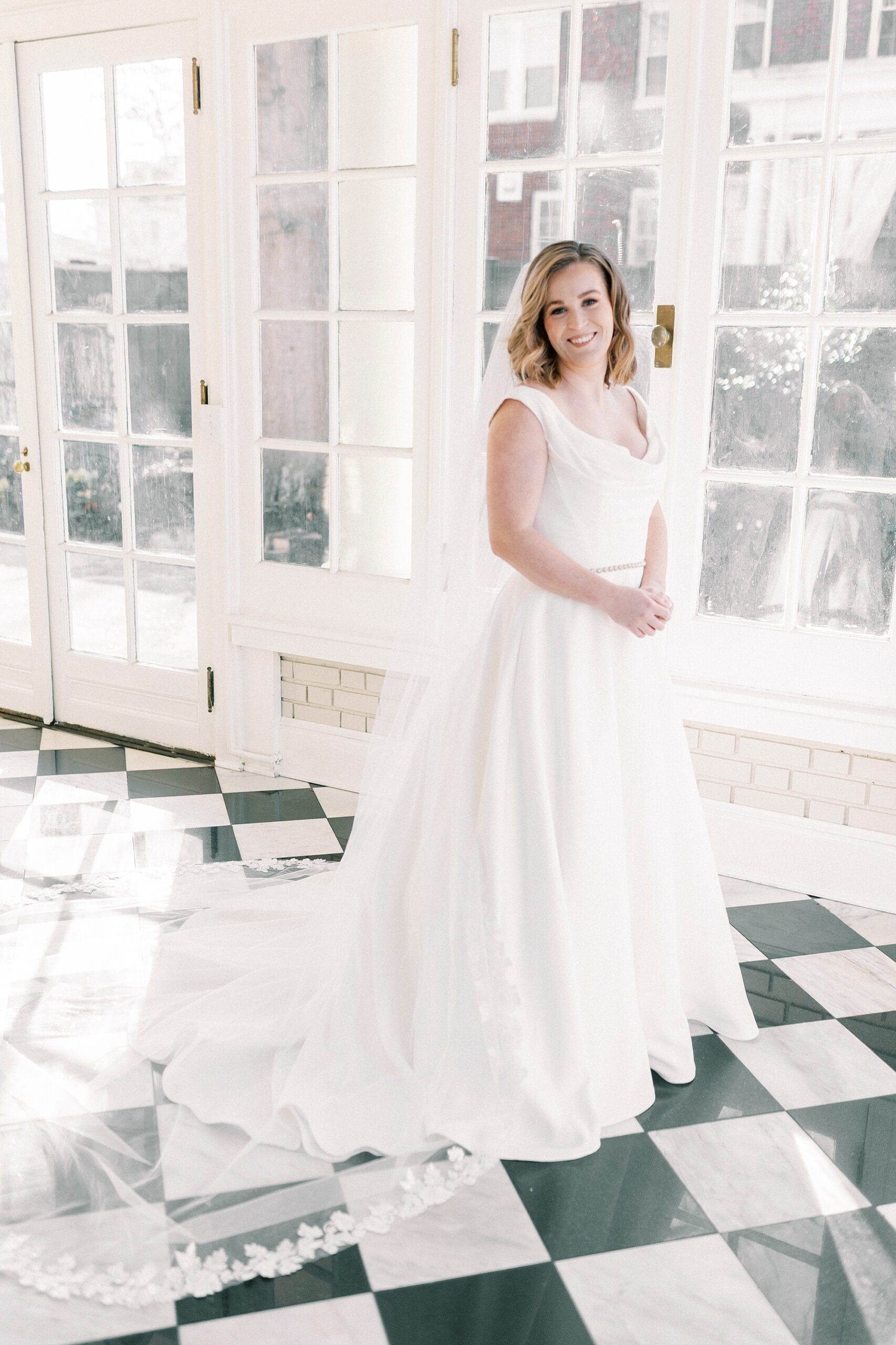 bride stands on black and white tile floor in wedding gown at Separk Mansion