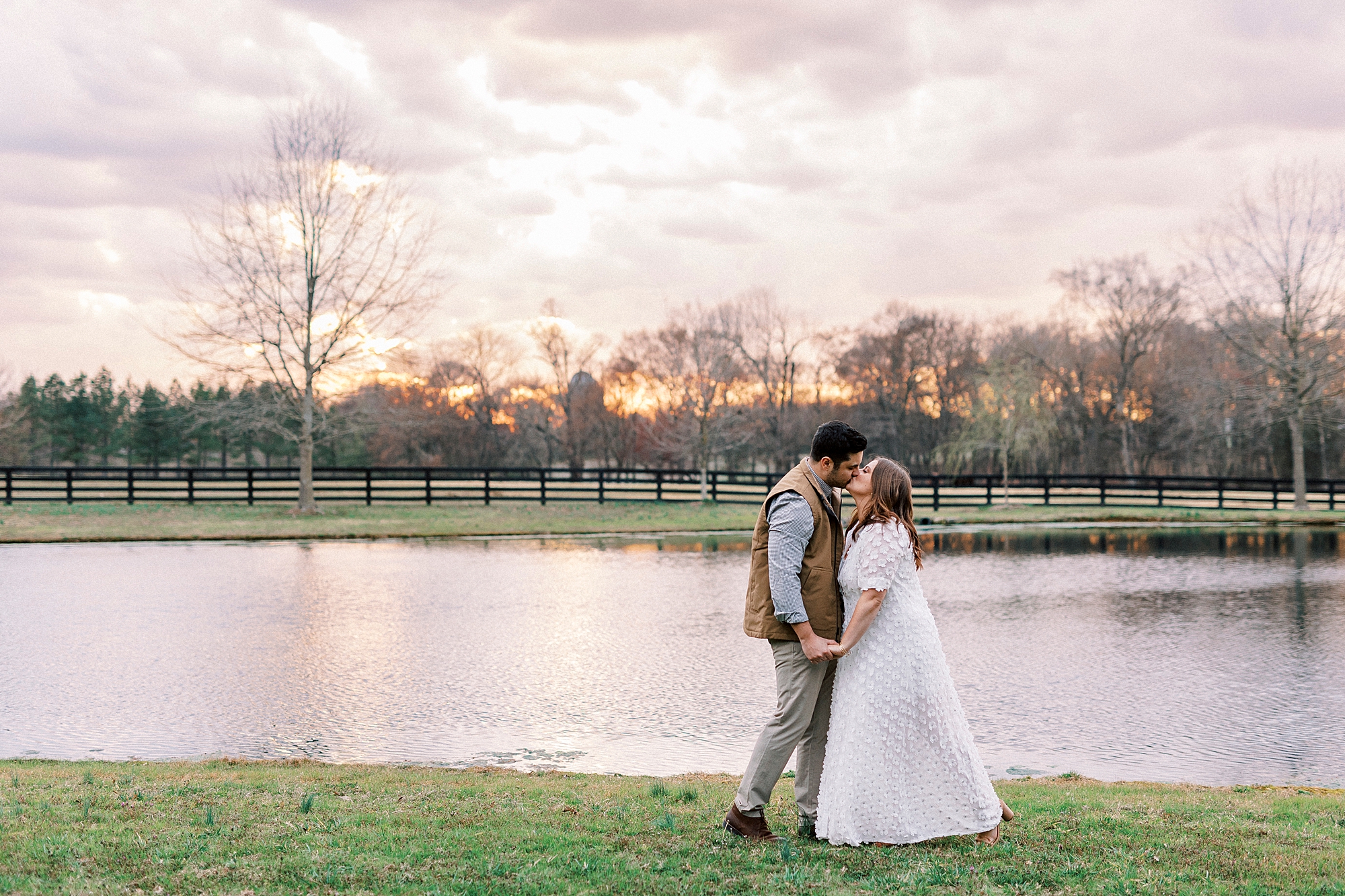 couple kisses by pond at sunset at Morning Glory Farm