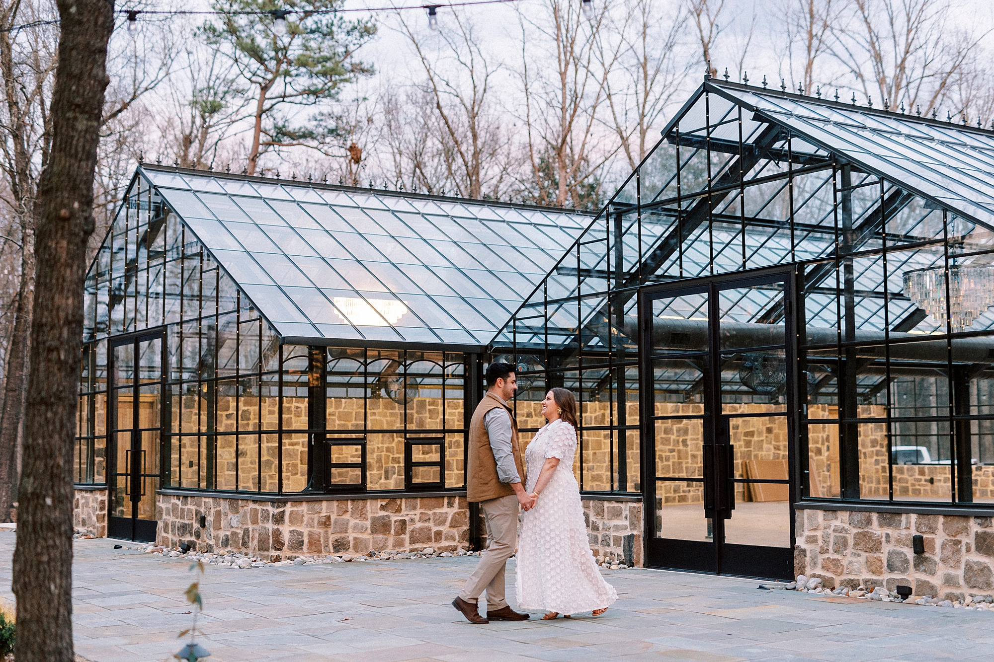 couple stands together outside greenhouses at Morning Glory Farm