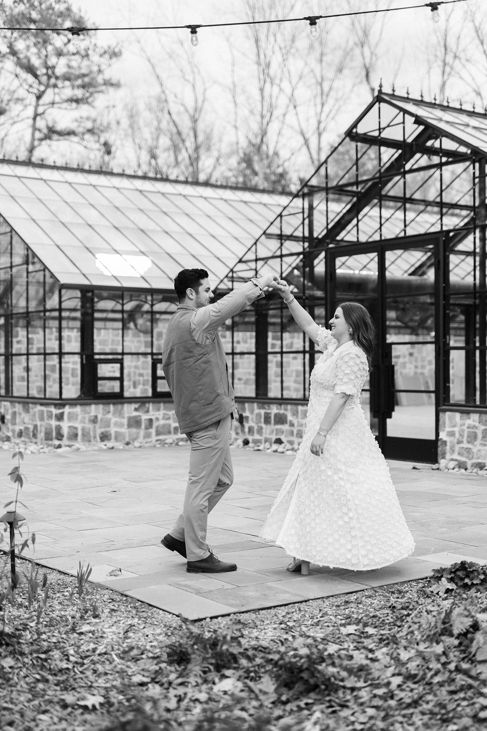 man twirls woman outside greenhouse at Morning Glory Farm