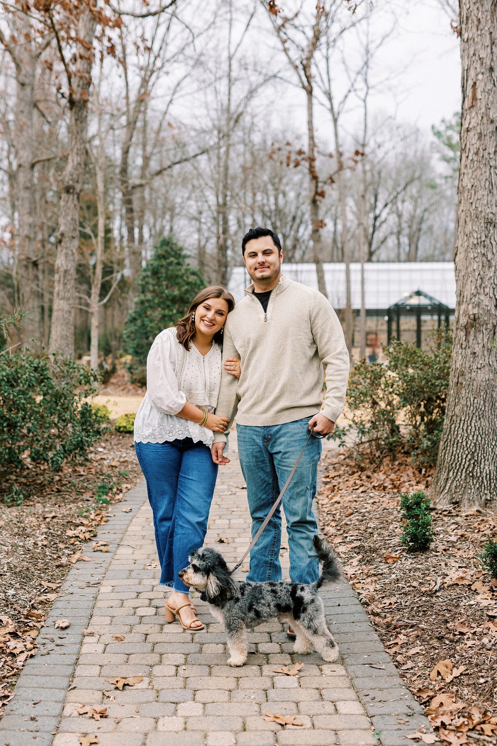 woman leans on man's arm while walking dog down path at Morning Glory Farm