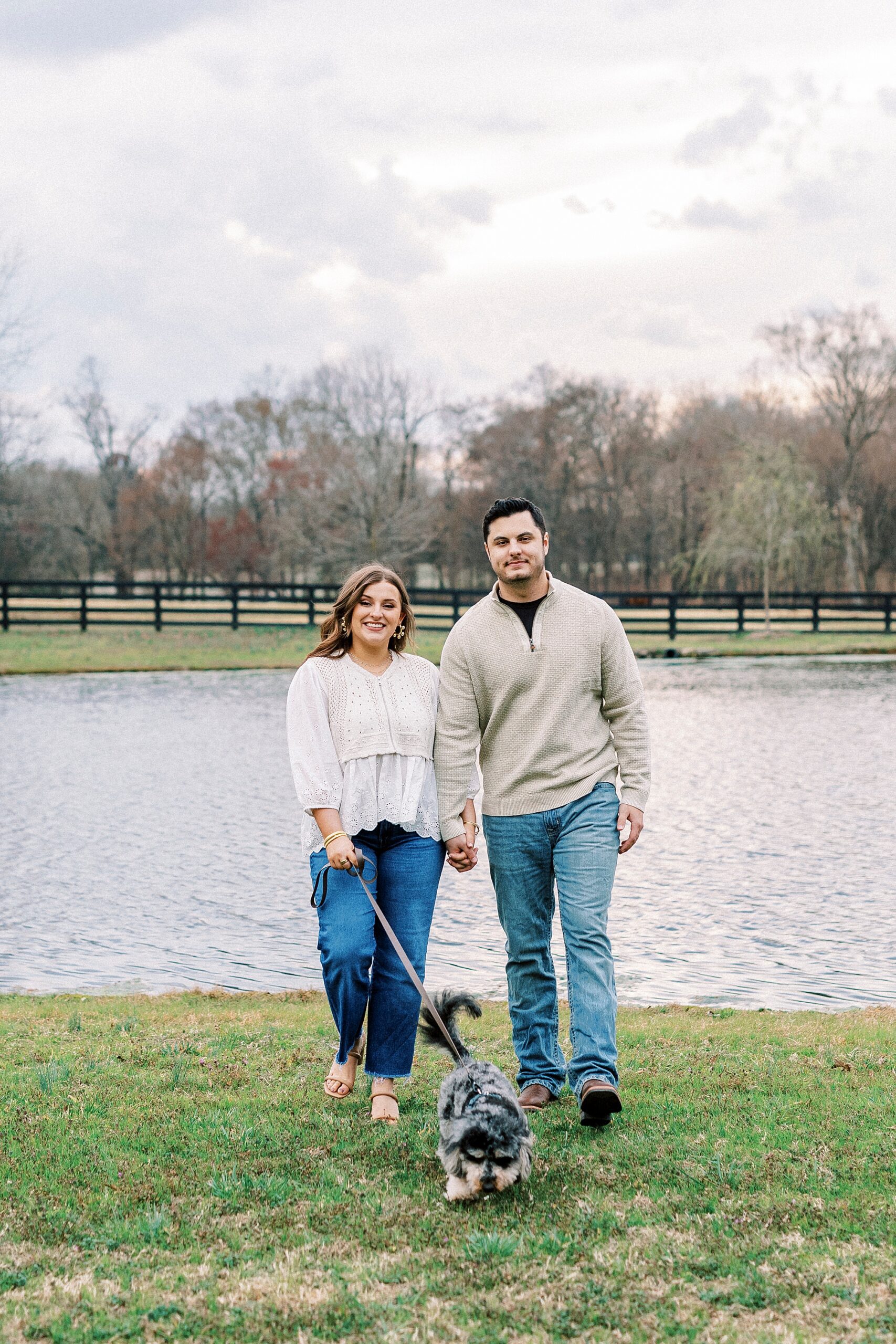 couple walks dog by pond during engagement session at Morning Glory Farm