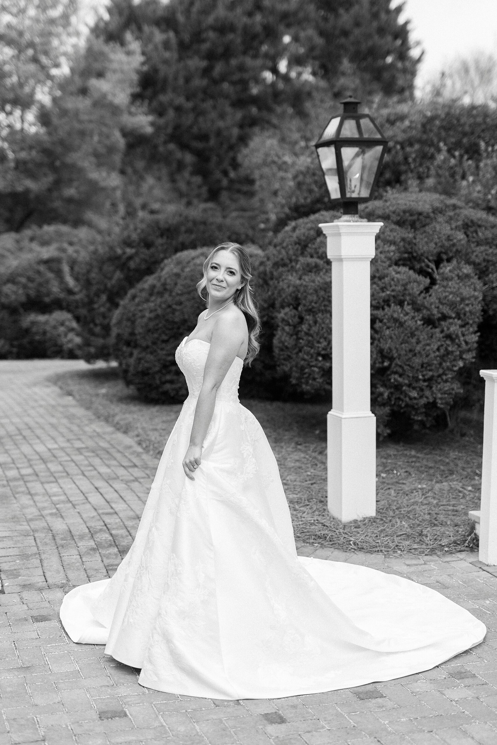 bride twirls wedding dress on brick pathway at the Sutherland in Wake Forest NC