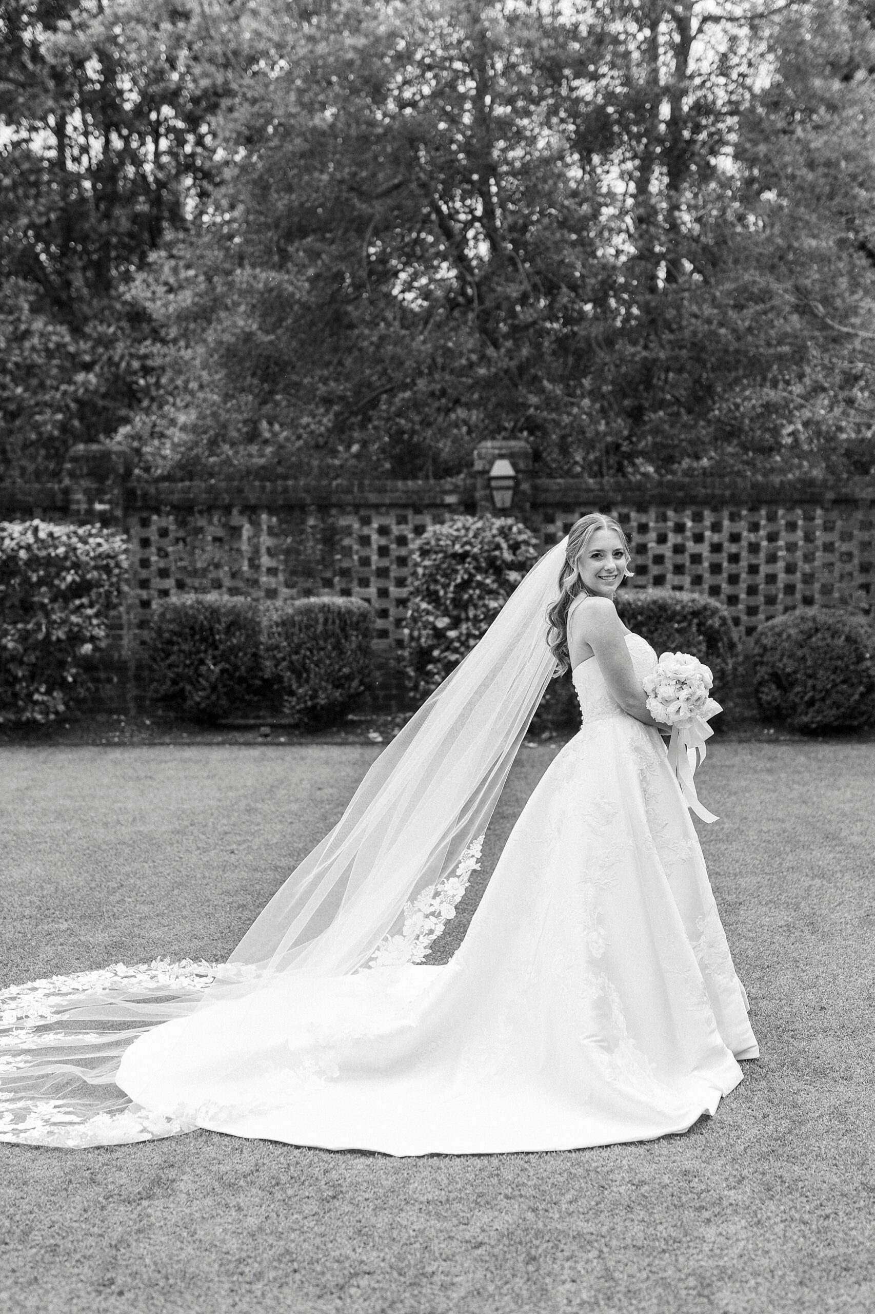 bride looks over shoulder with veil dragging behind her in courtyard of the Sutherland