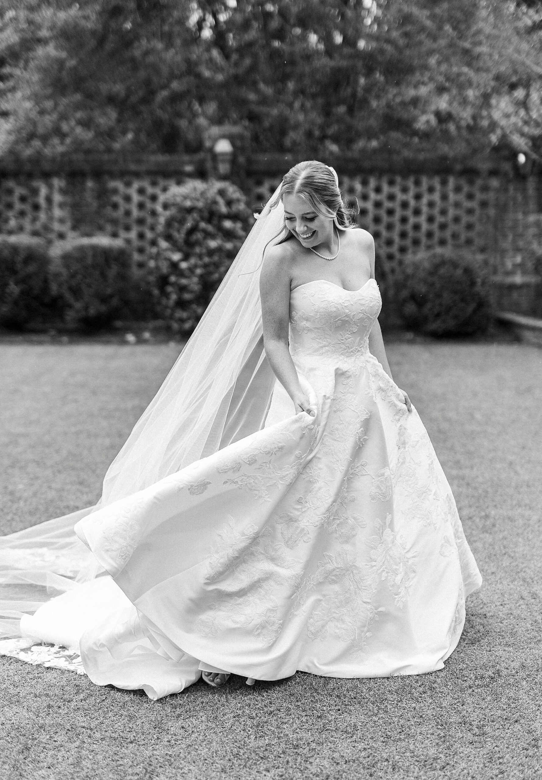 bride grins twirling on lawn in courtyard at the Sutherland