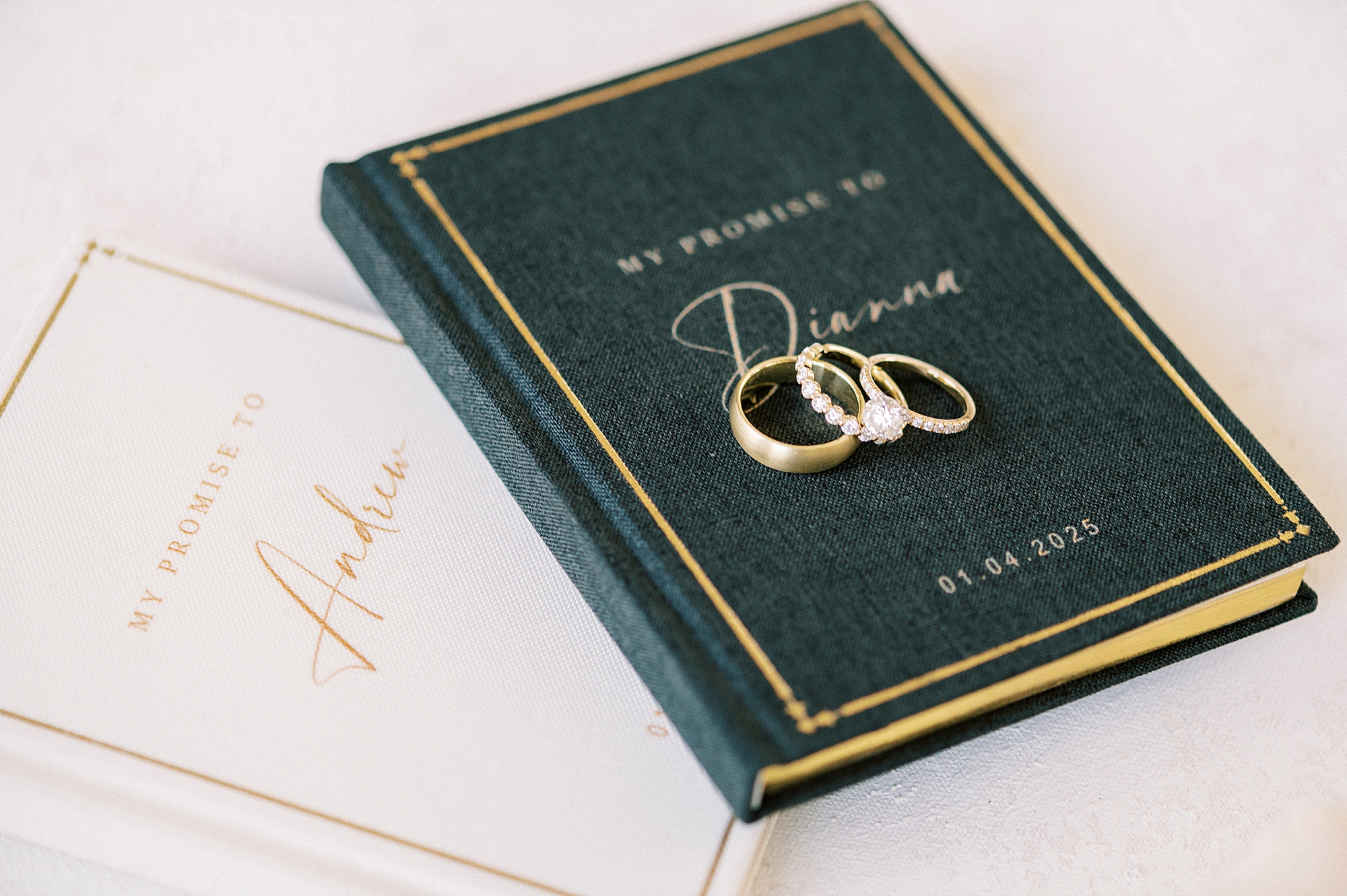 green and white vow booklets with gold wedding bands for winter wedding