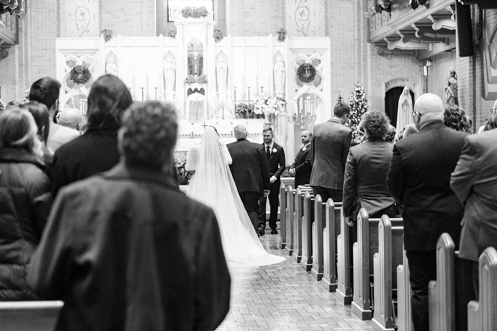 bride and father walk down aisle for traditional church wedding inside Our Lady of Grace
