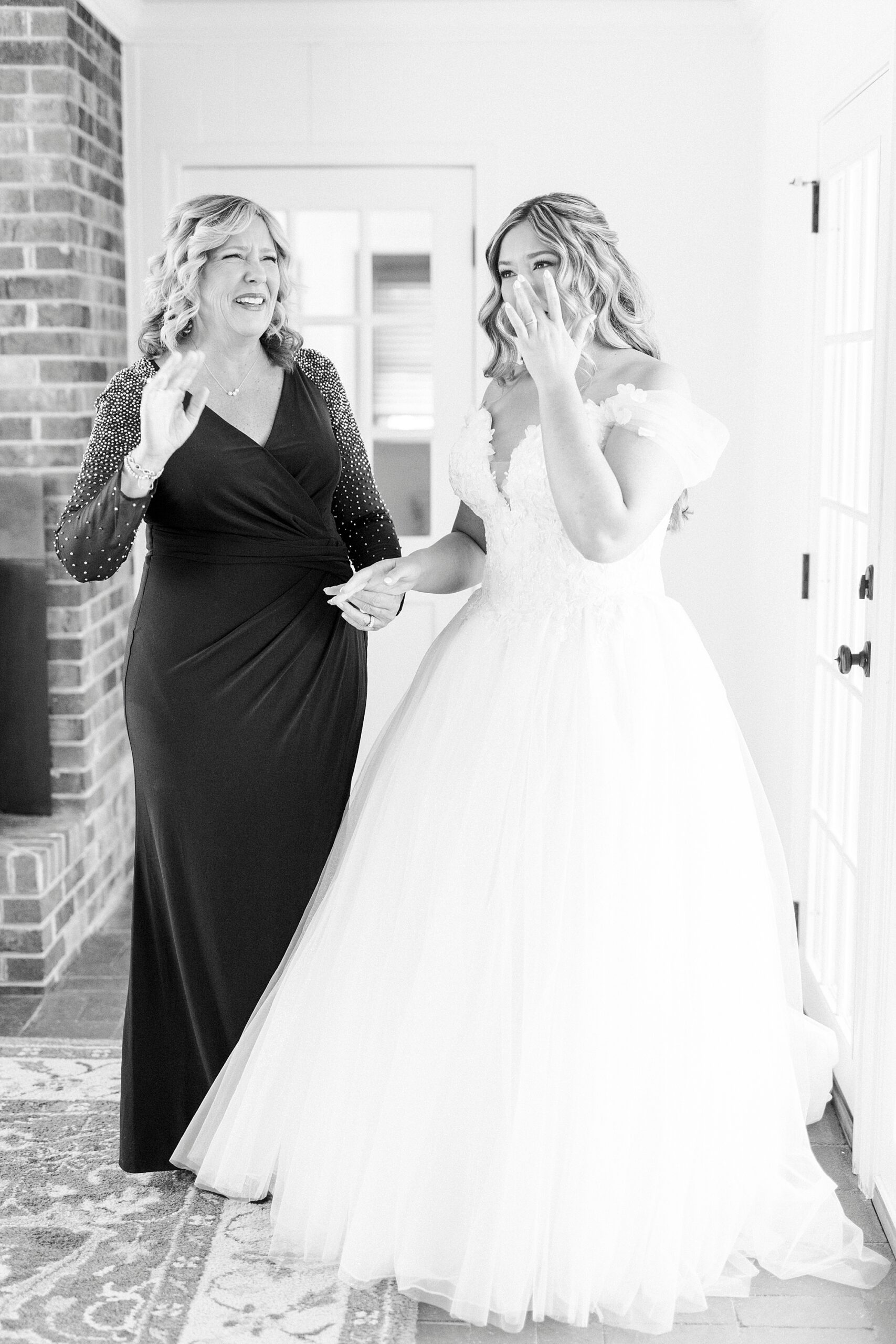bride holds mom's hand during prep at Summerfield Farms