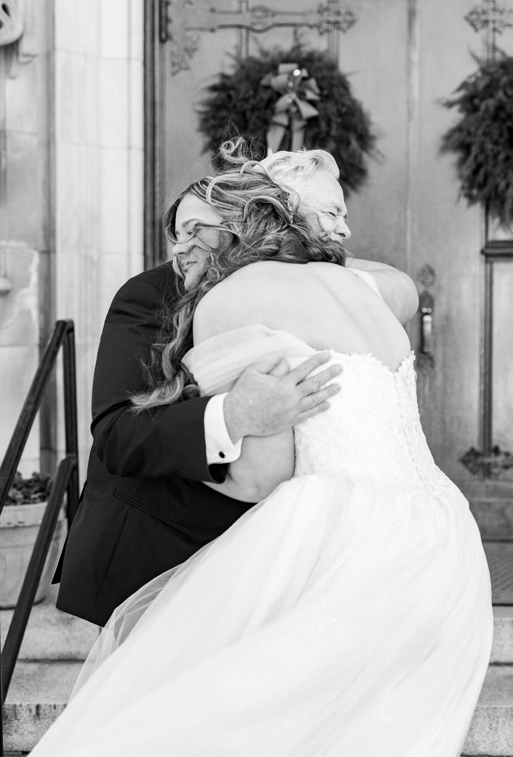 bride and dad hug during first look outside Our Lady of Grace