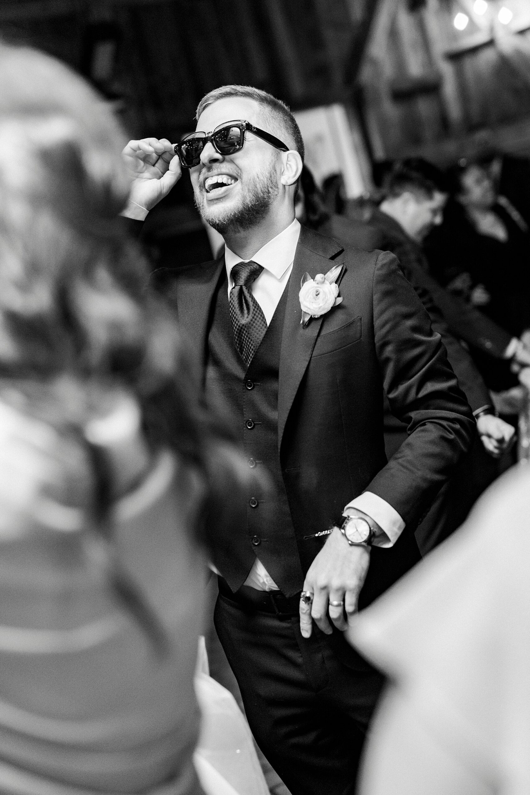 groom dances during reception with sunglasses on in barn at Summerfield Farms