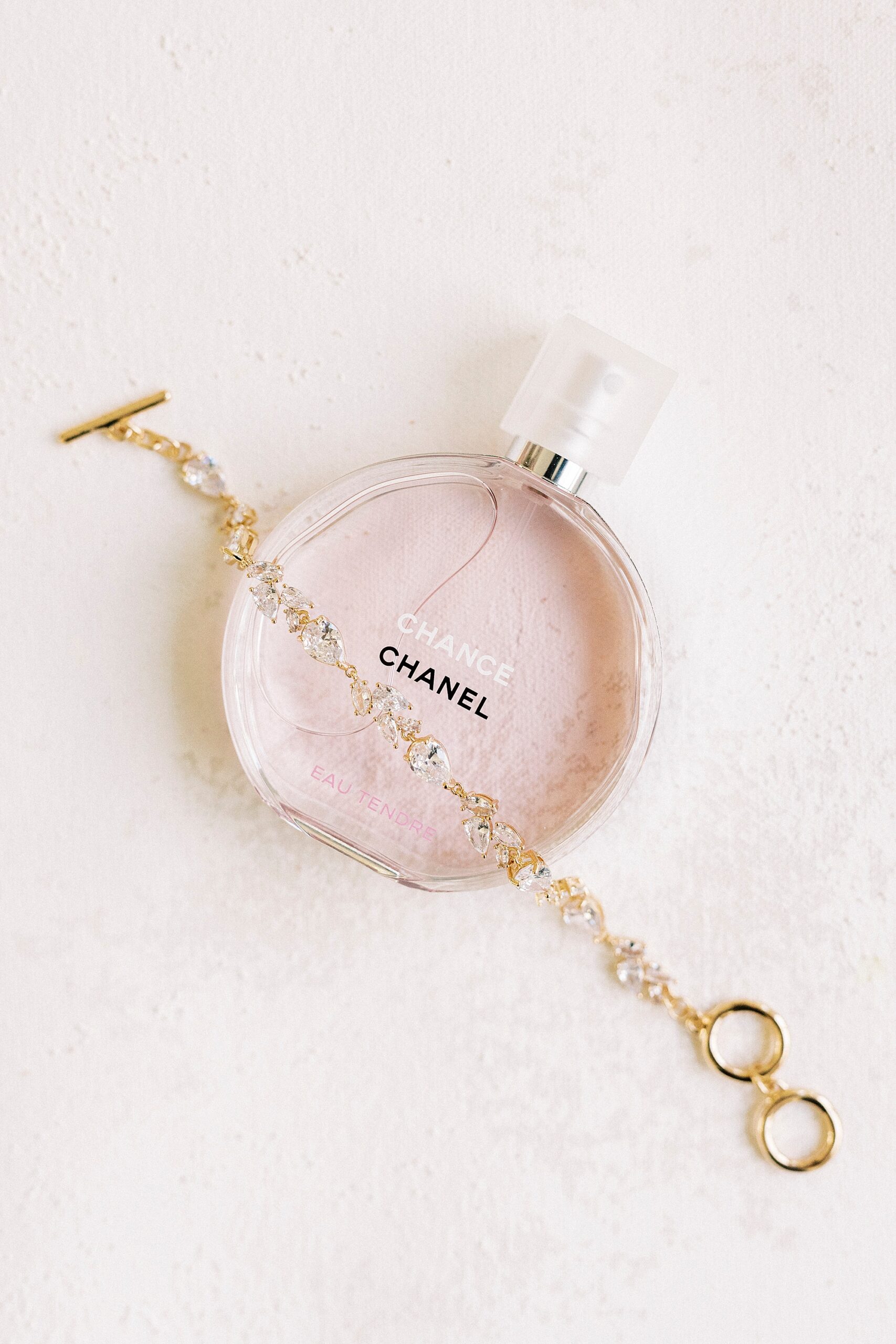 pink perfume bottle over top gold chain for winter wedding