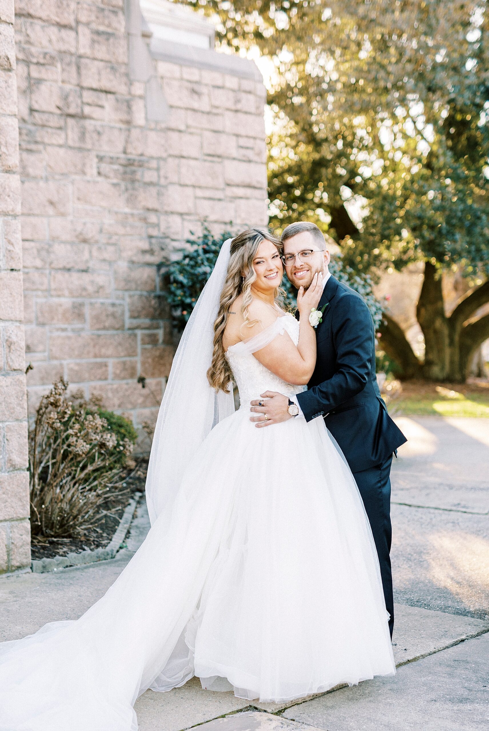 bride and groom hug outside Our Lady of Grace 