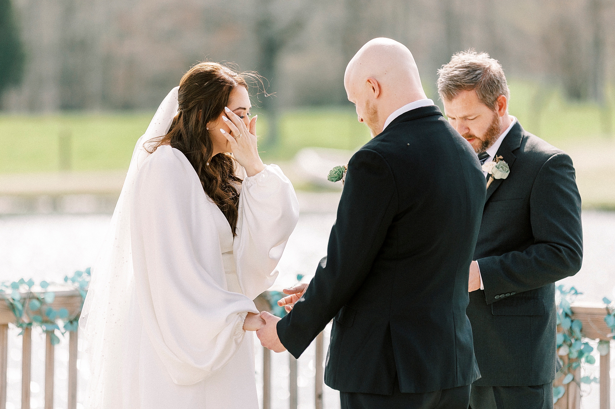 bride wipes away tears from her cheek during wedding ceremony in Mount Pleasant NC