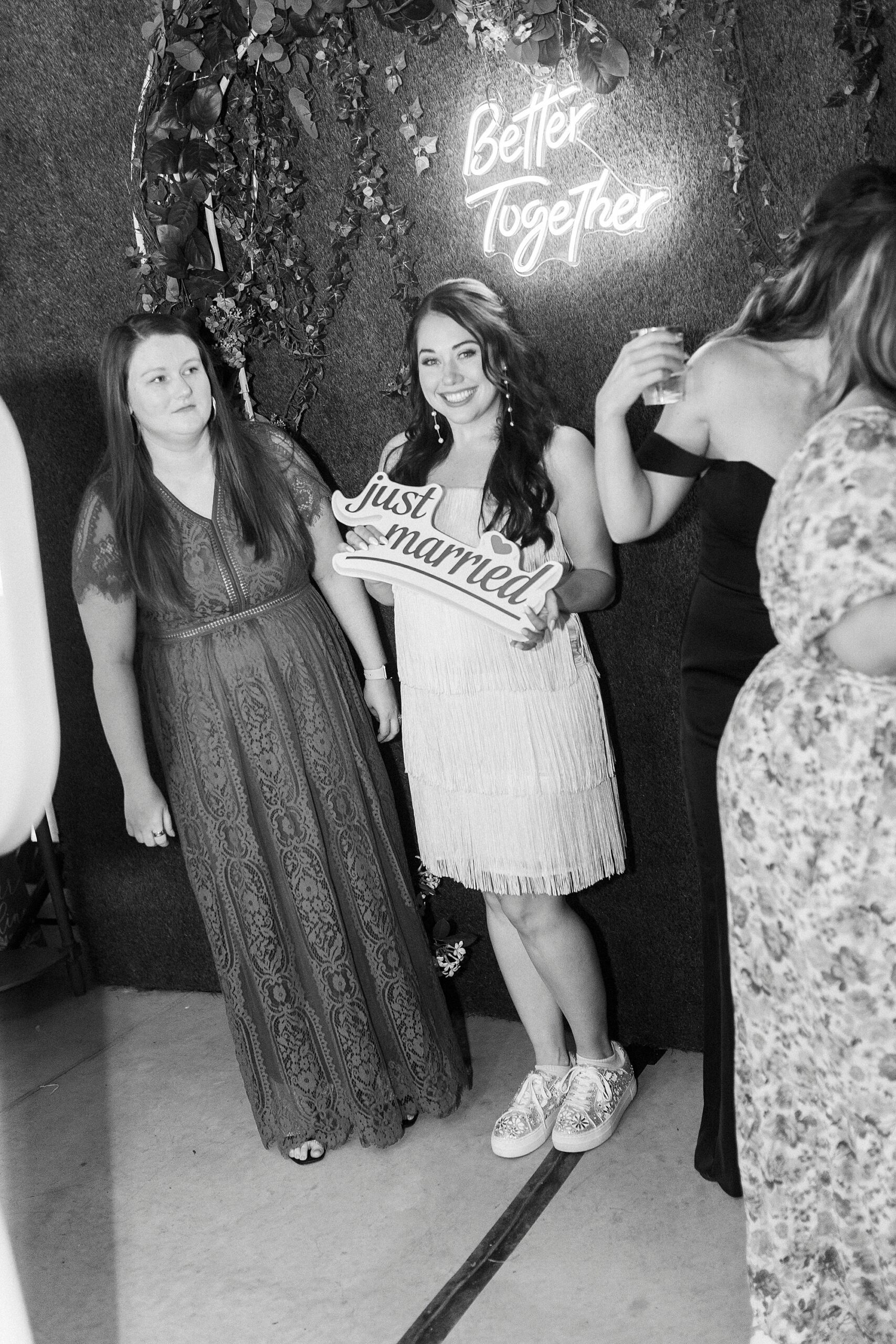 bride holds up fun sign in photo booth during during wedding reception in Mount Pleasant NC