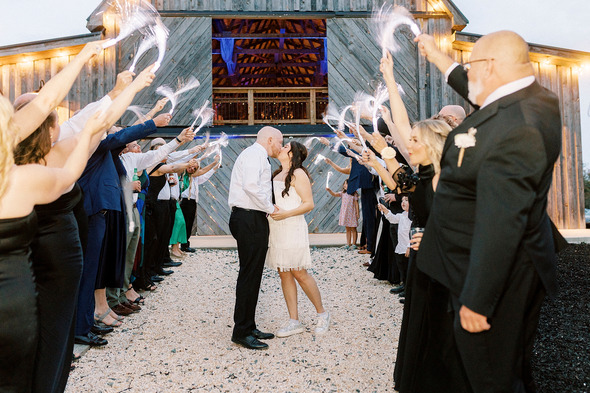 bride and groom kiss during glow stick exit from during wedding reception in Mount Pleasant NC