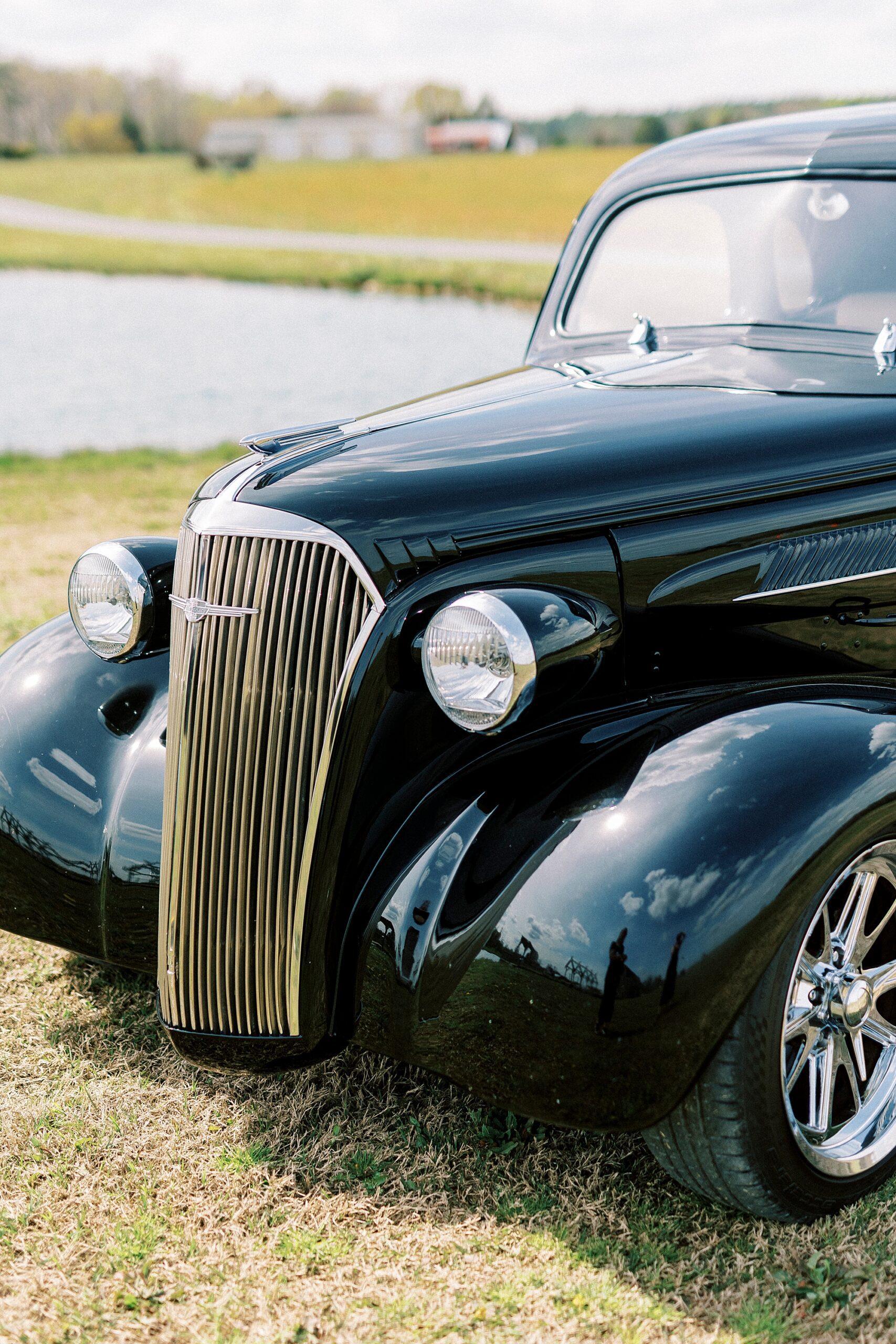 front of classic black car for farm wedding