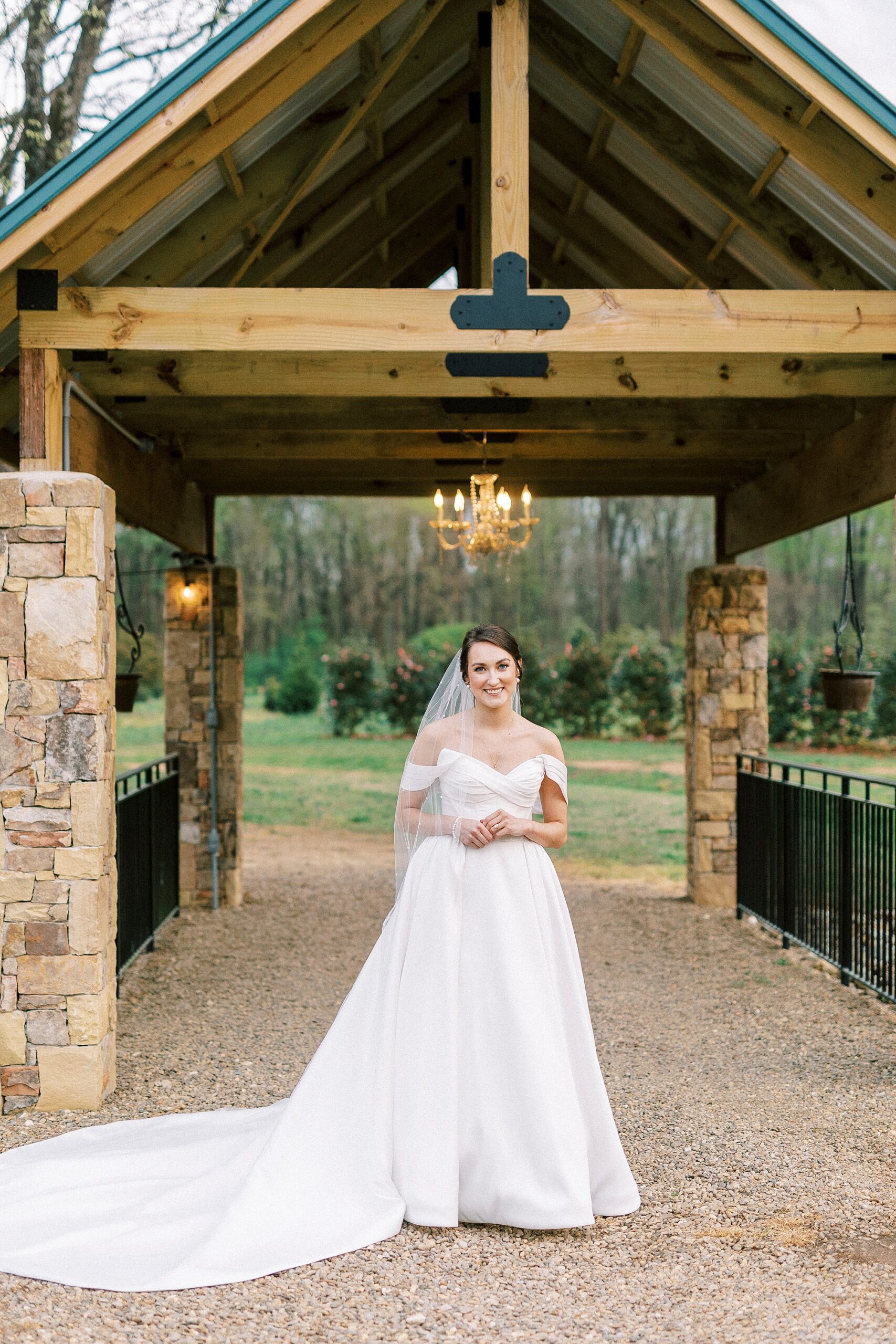 bride walks under covered bridge in Mount Holly NC