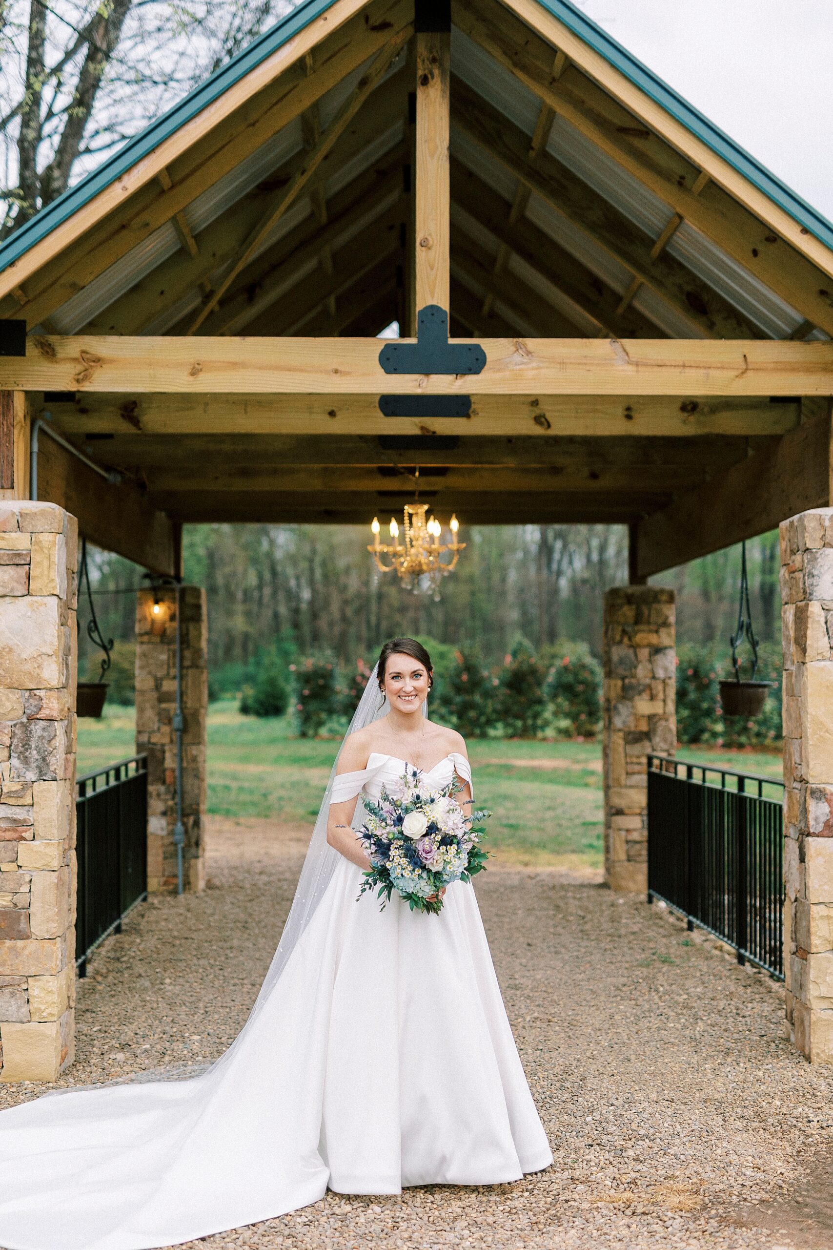 bride walks under covered bridge in Mount Holly NC