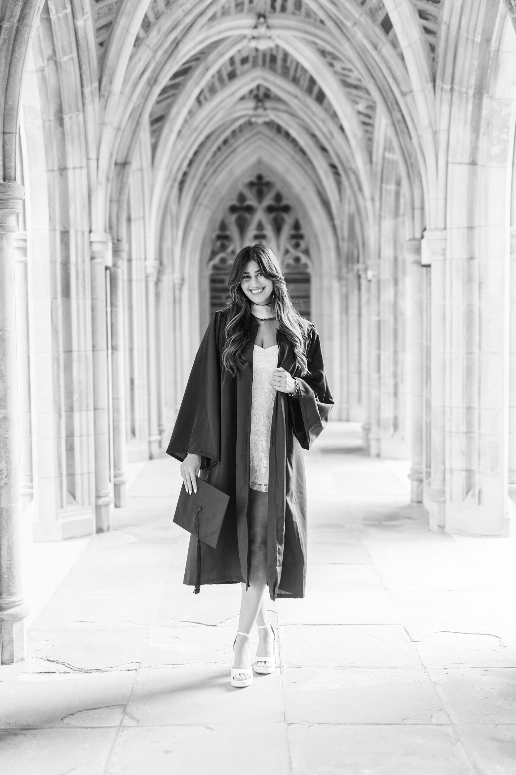 senior poses in arches of Duke Chapel