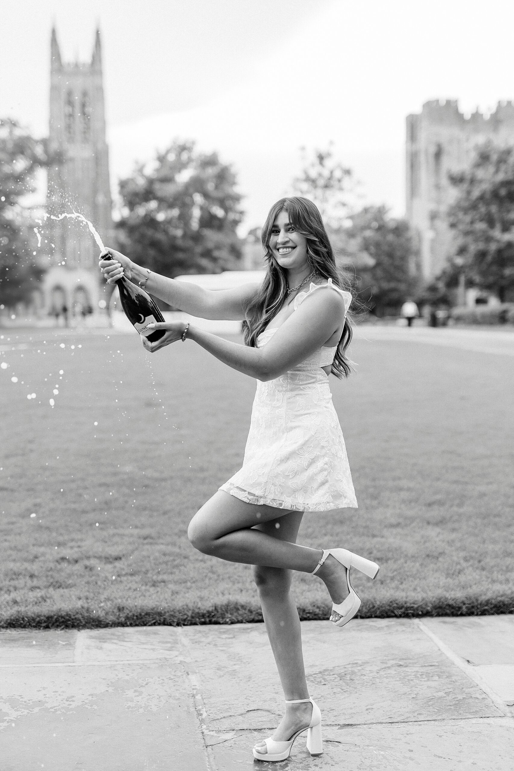 college student pops champagne during Duke Chapel graduation portraits