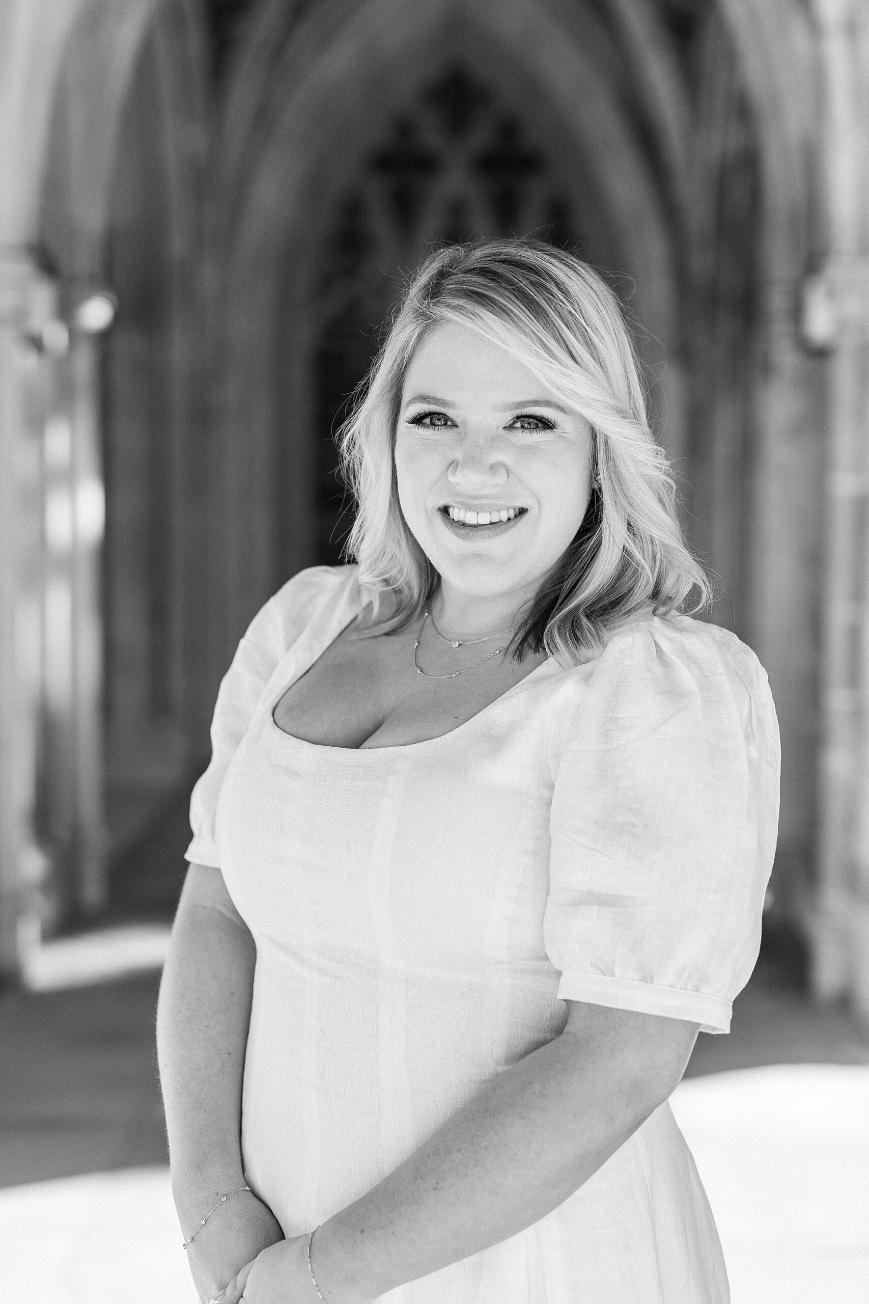 black and white photo of woman in white dress in front of Duke Chapel 