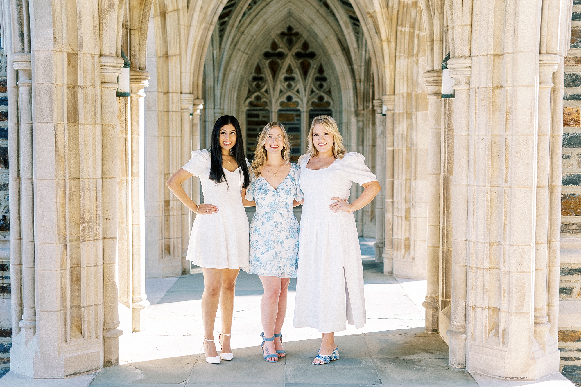 three graduates stand together at Duke University Chapel 