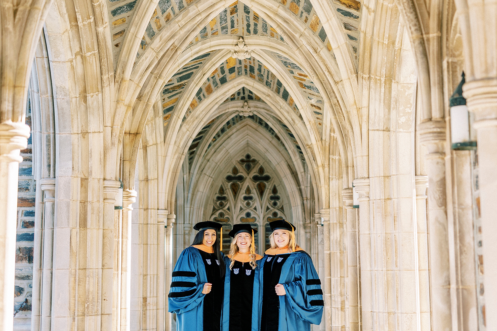 three graduates pose in Duke Chapel during graduation portraits 
