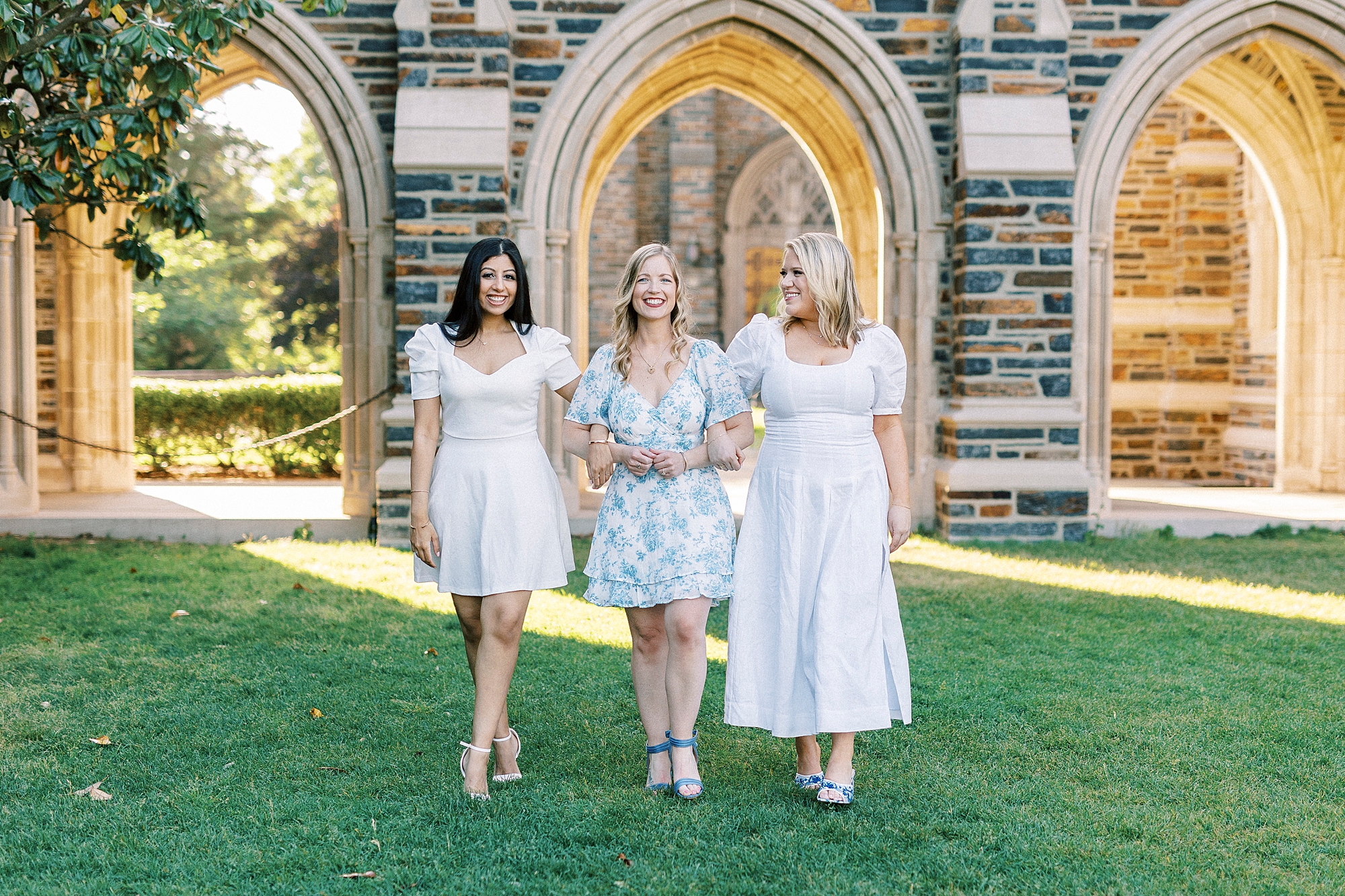women walk with arms linked during graduation portraits at Duke University