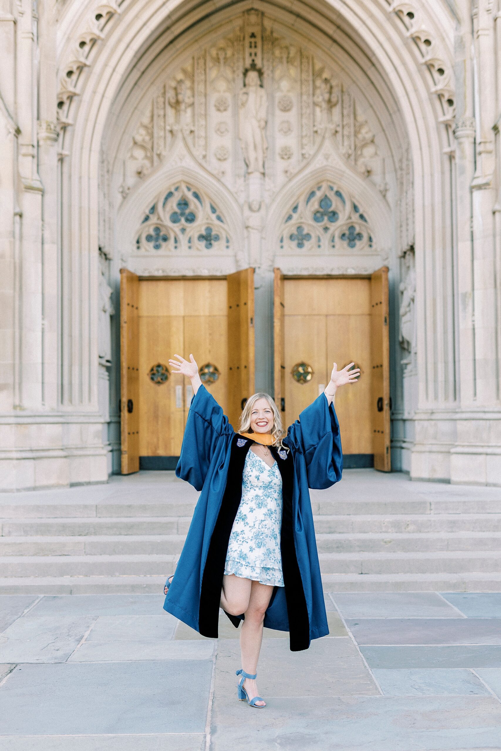 woman stands with hands in the air during graduation portraits at Duke University