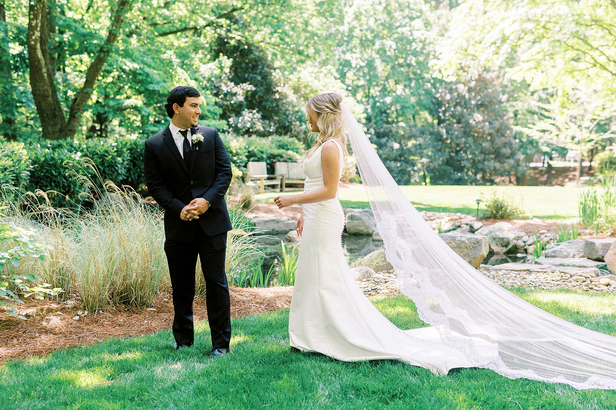 bride approaches groom for first look on lawn at Morning Glory Farm