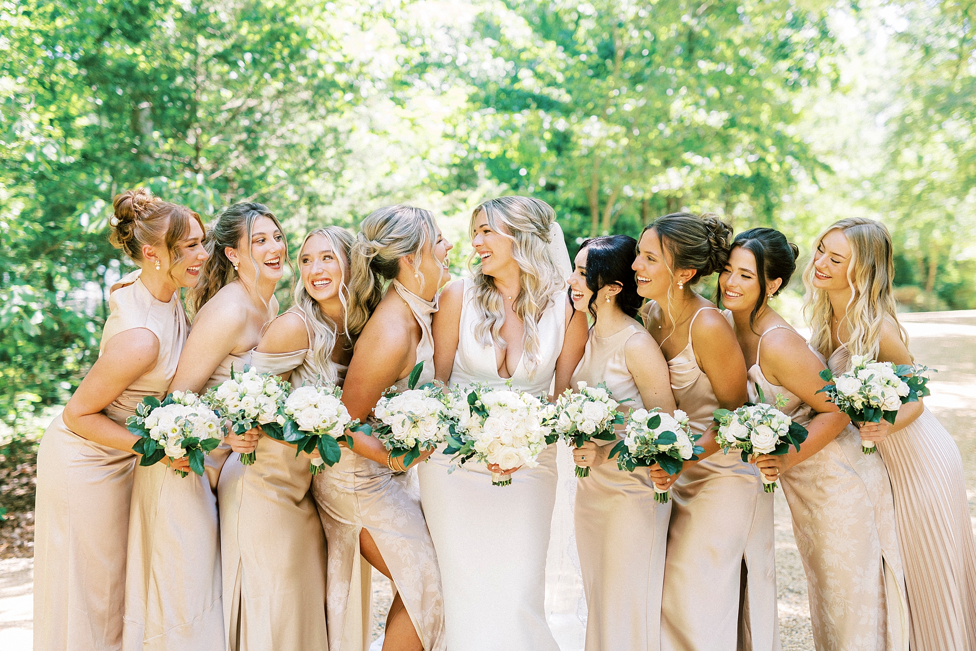 bride and bridesmaids in champagne gowns hug at Morning Glory Farm