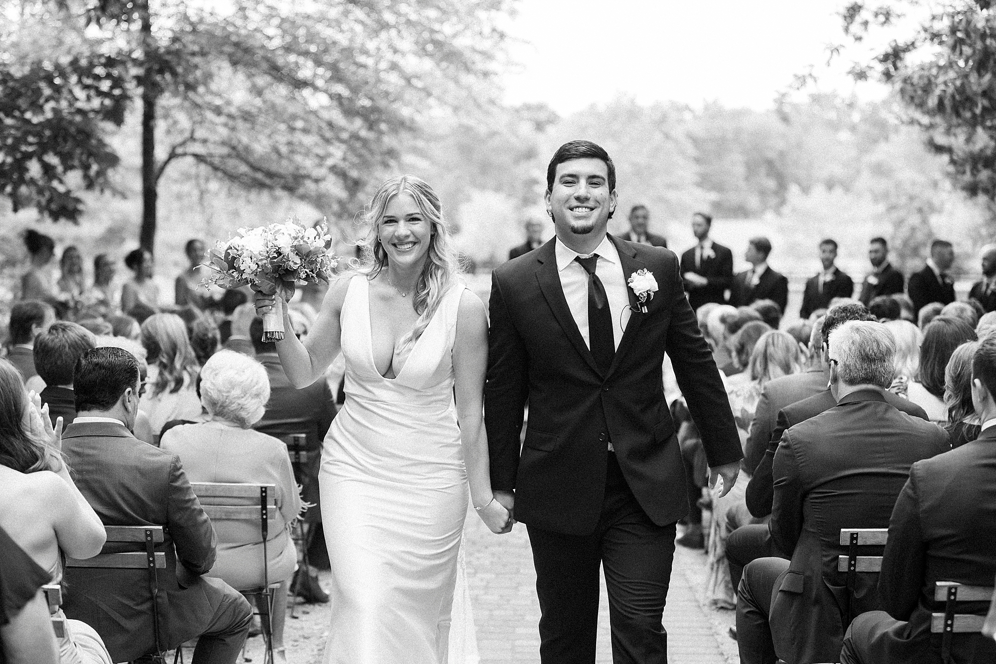 bride and groom hold hands recessing up aisle after ceremony at Morning Glory Farm