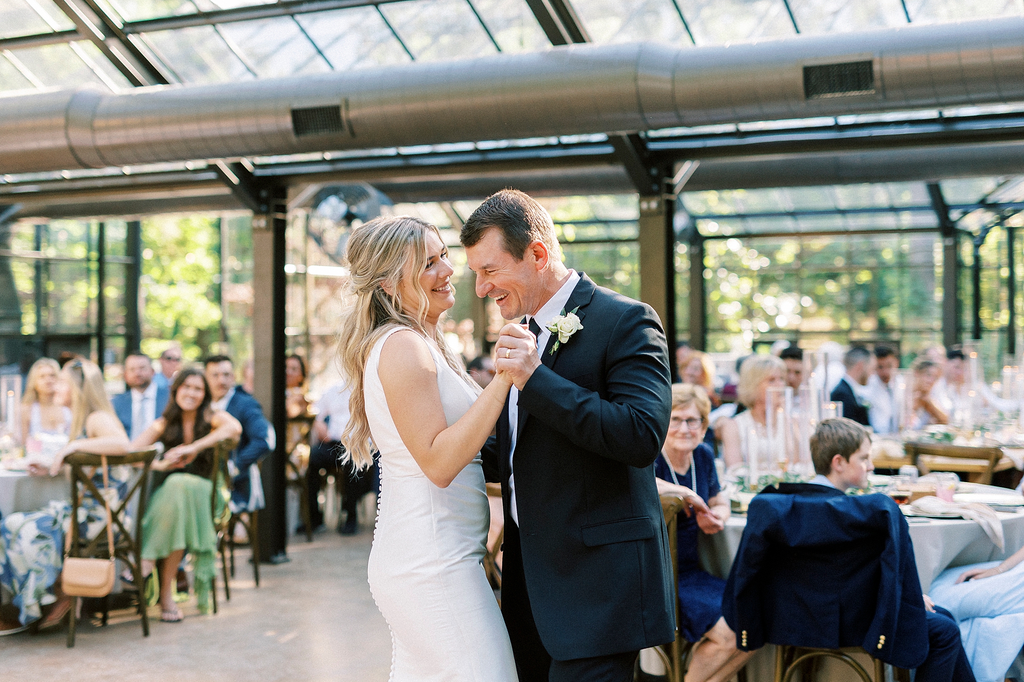 bride and father dance during wedding reception in glass greenhouse at Morning Glory Farm