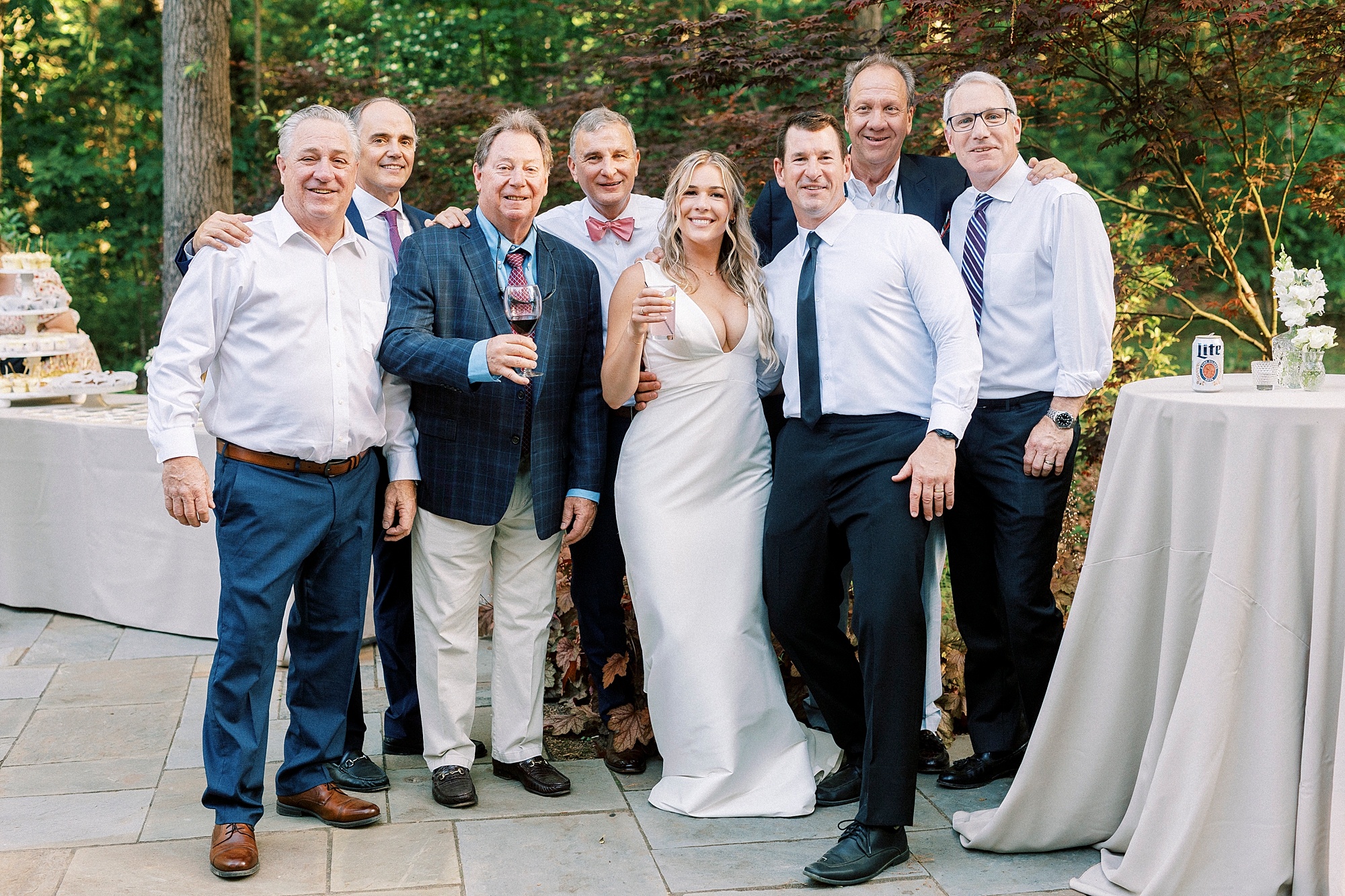 bride poses with wedding guests during cocktail hour at Morning Glory Farm
