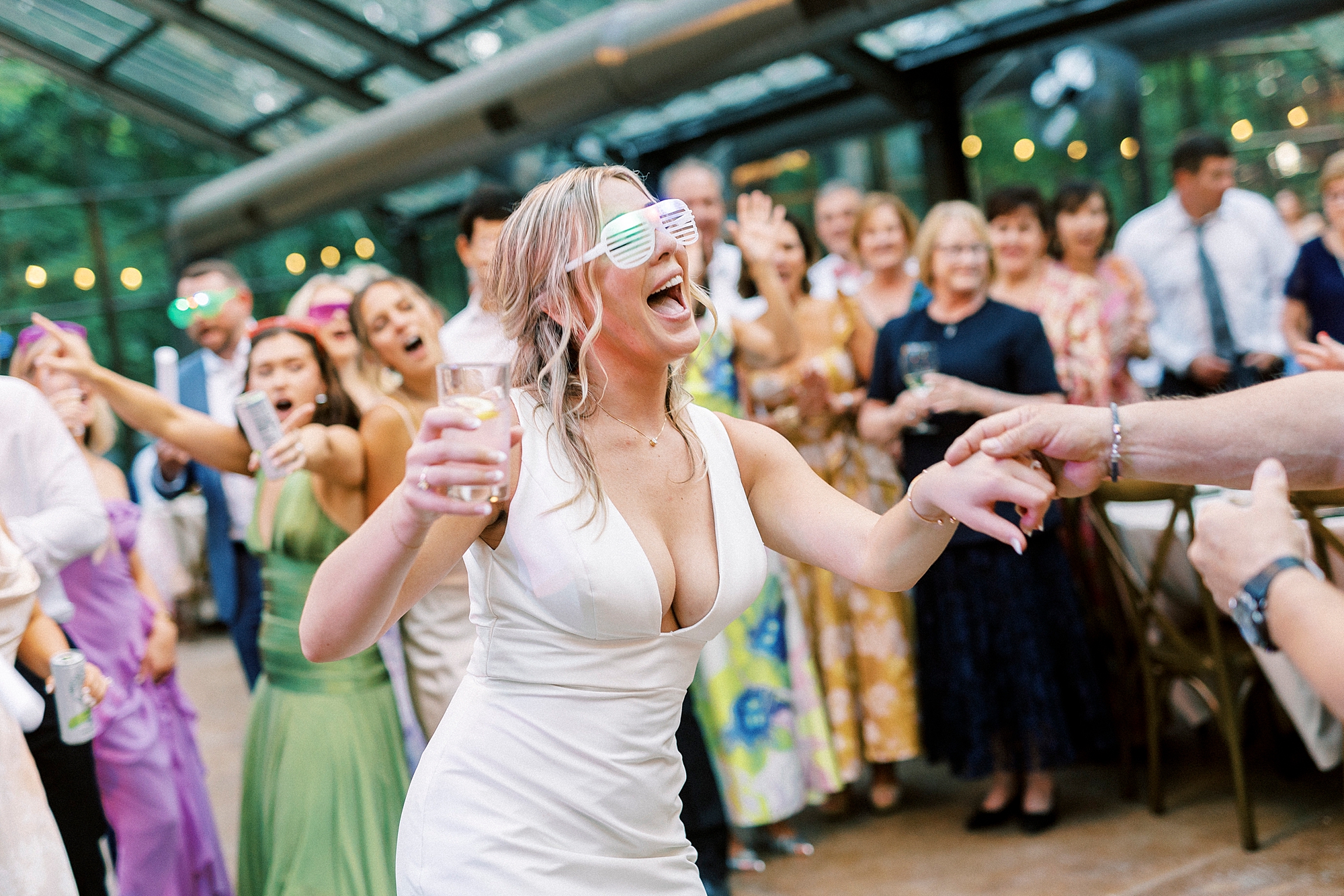 bride dances in neon glasses during wedding reception at Morning Glory Farm